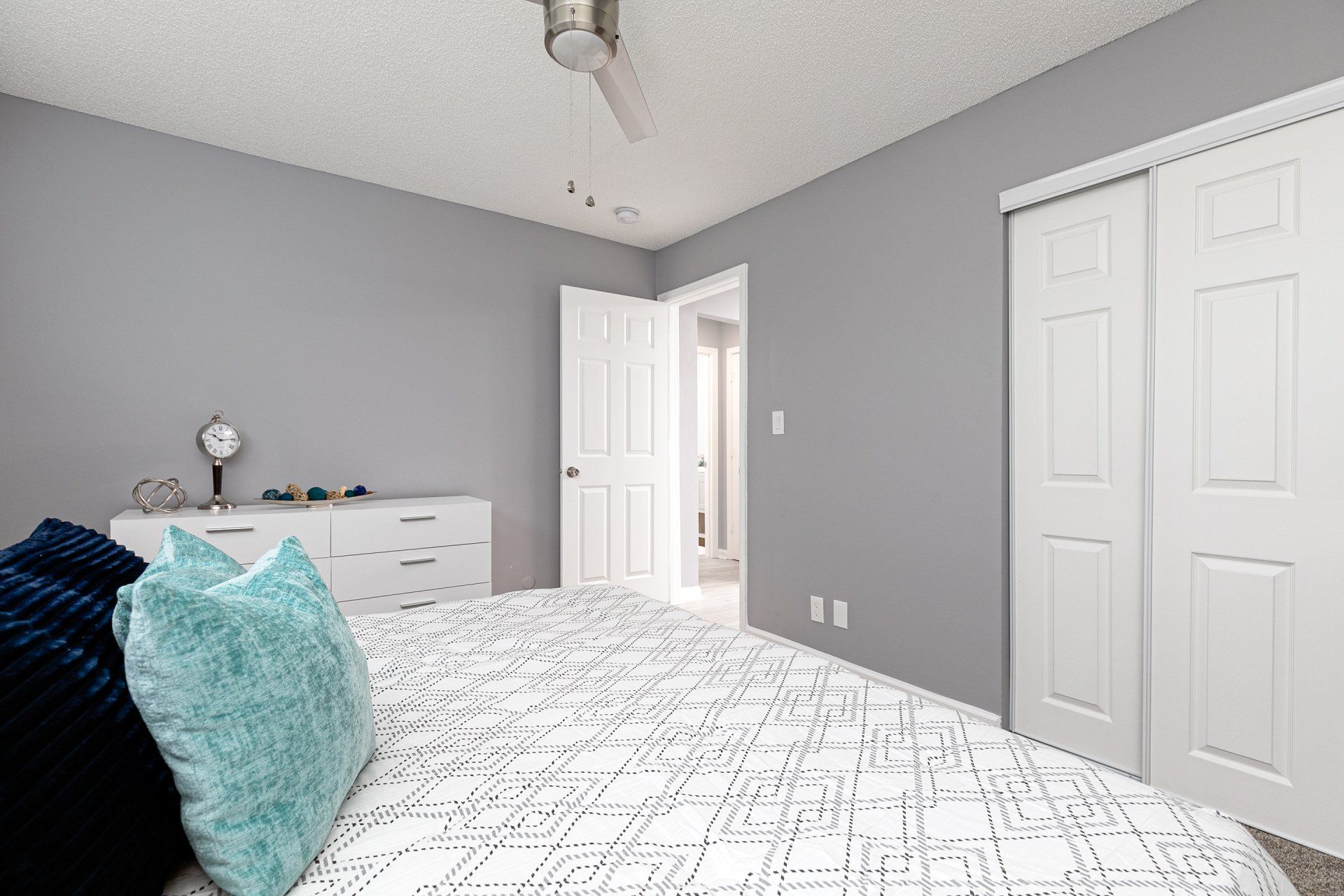 Pet-Friendly Apartments In Sylvan Hills, GA - Gateway South - Spacious Bedroom With New Carpet, Large Bed, Ceiling Fan, And Large Closets With Sliding Doors.