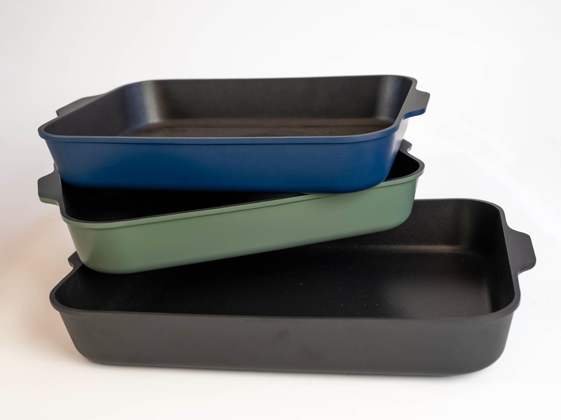 Three colourful rectangular baking dishes stacked on top of each other.