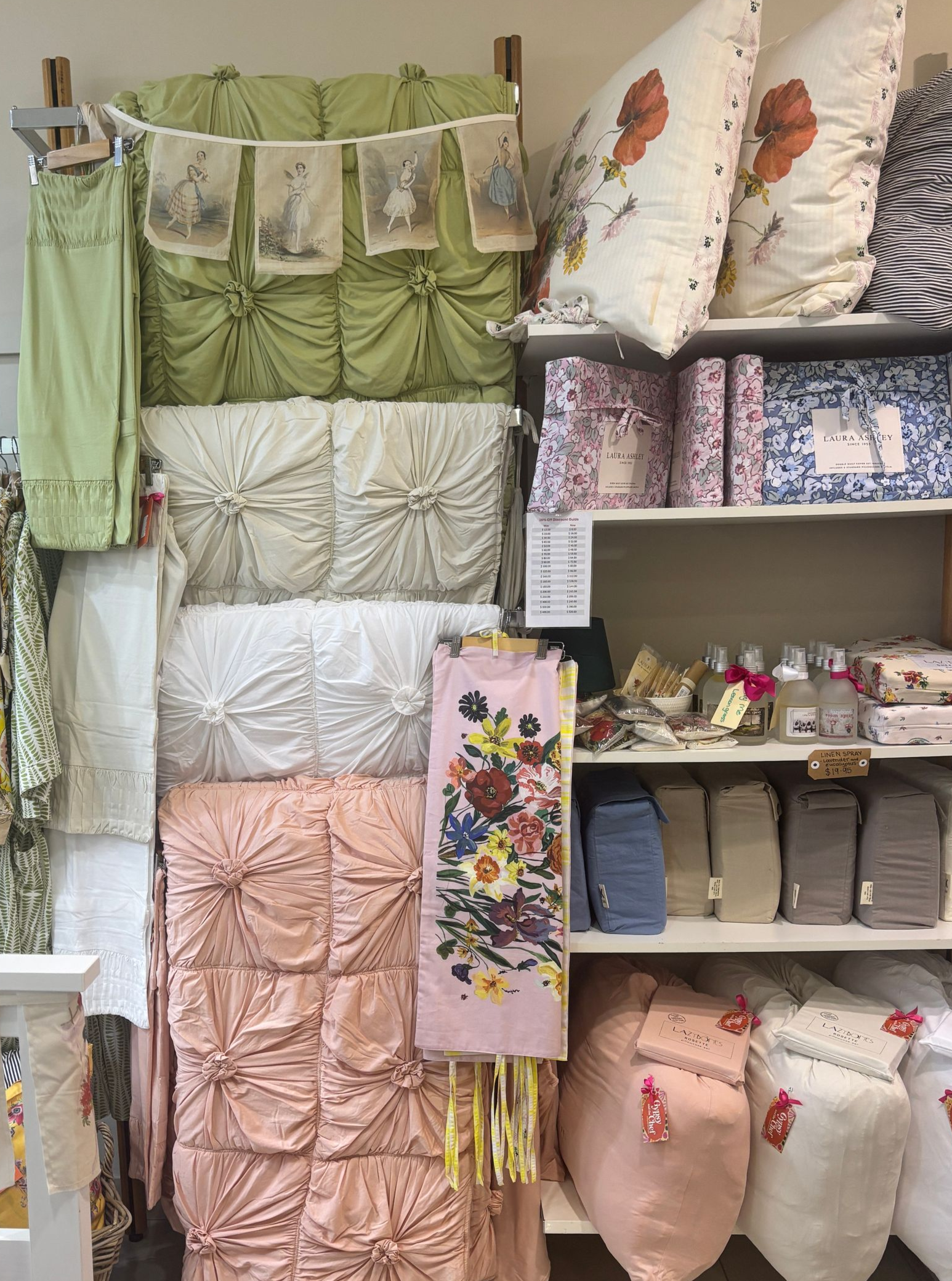 Display of decorative pillows and fabrics in various colours and patterns on shelves.