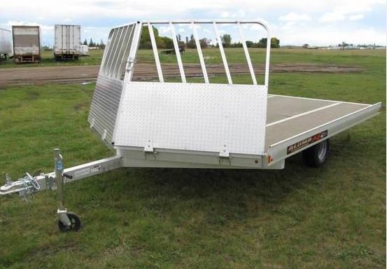 A trailer is parked in the snow in a field.