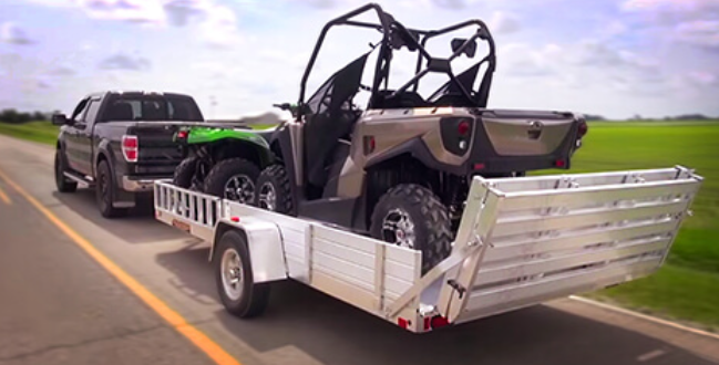 The inside of a trailer with a wooden floor and white walls.