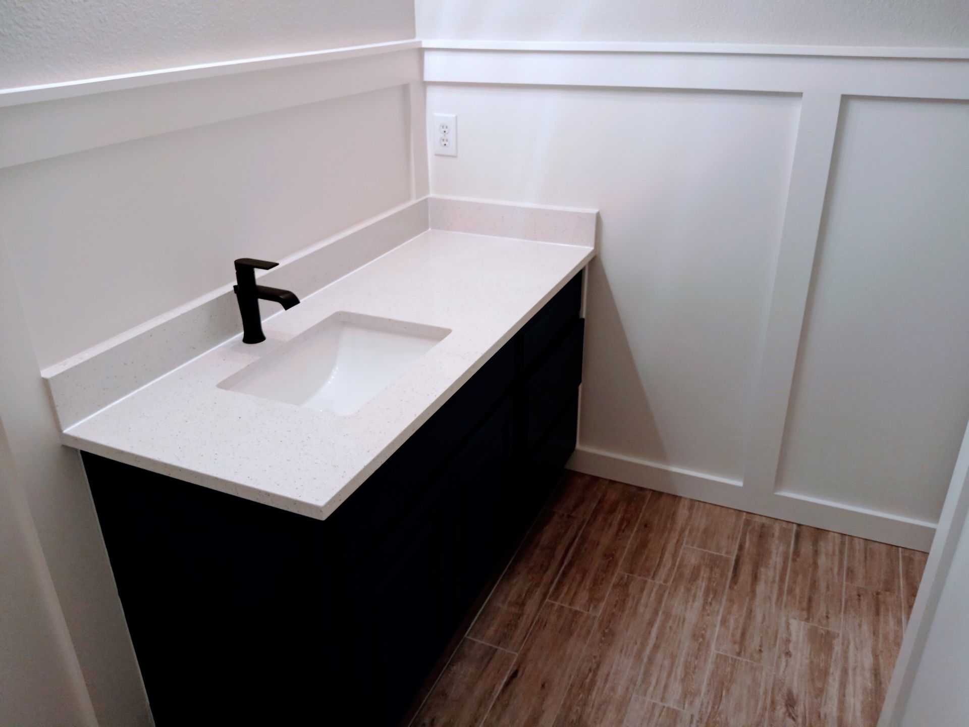 A bathroom with a sink and a black faucet