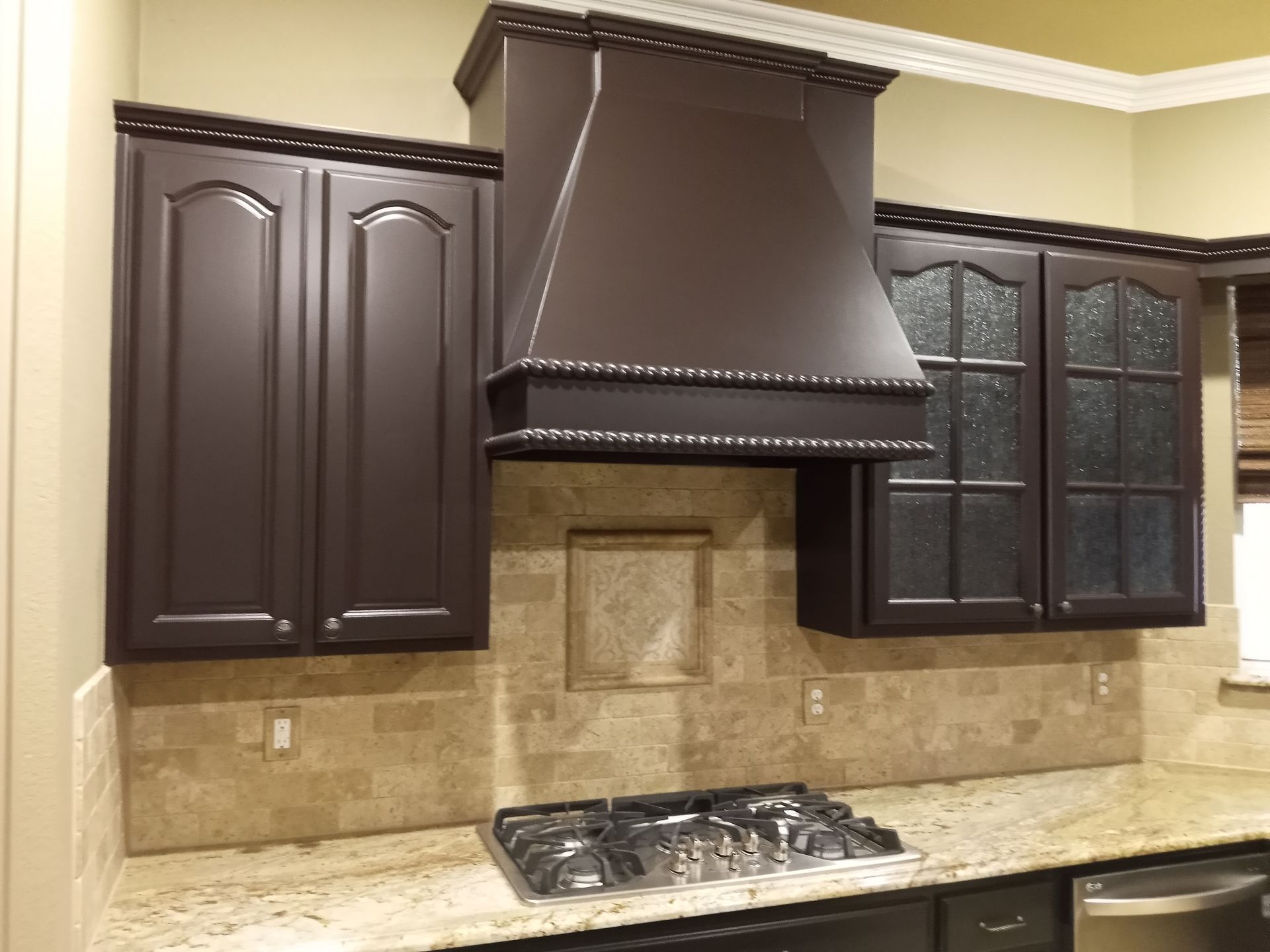 A kitchen with brown cabinets and a stove top oven