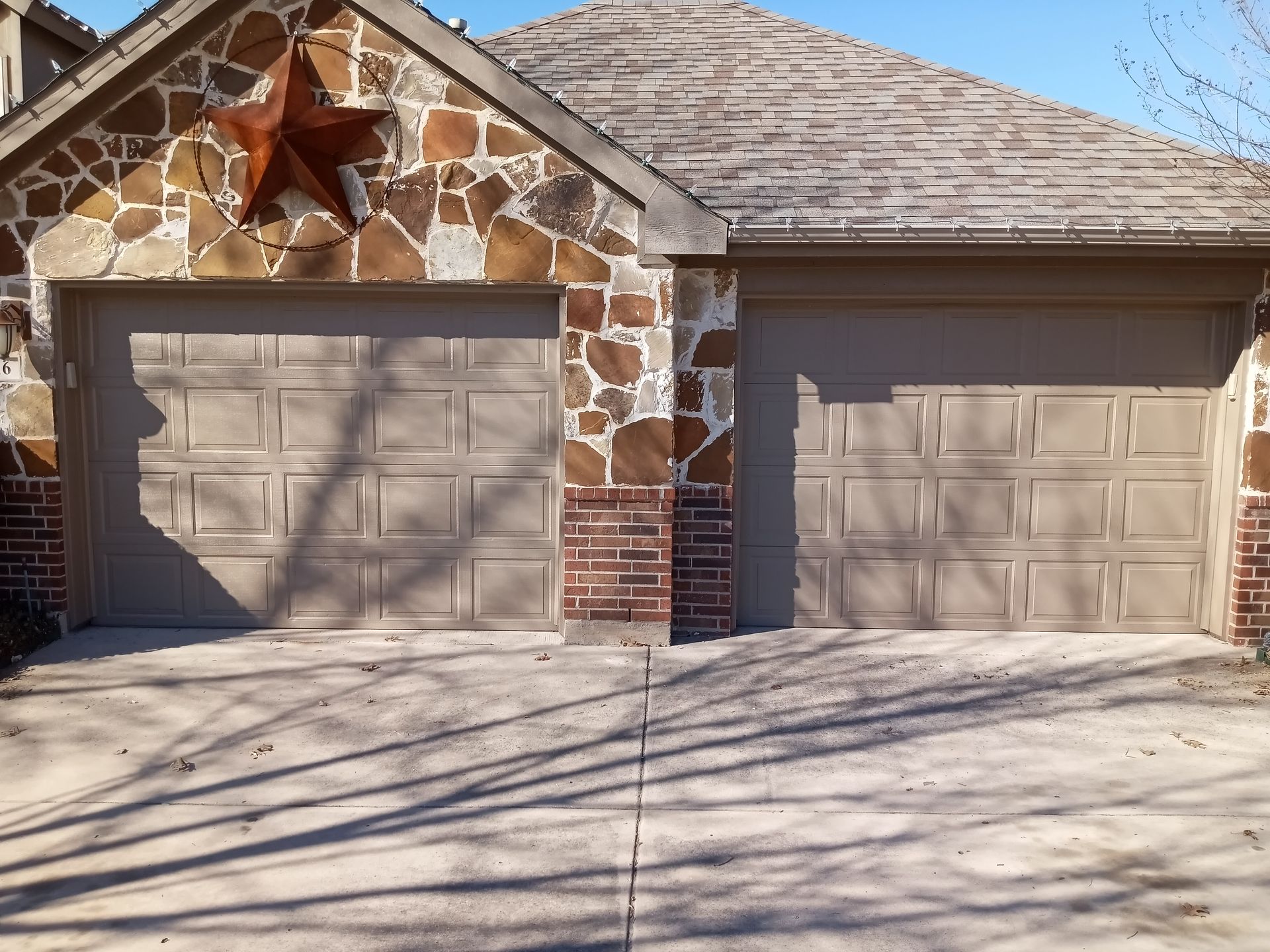 A house with two garage doors and a star on the roof