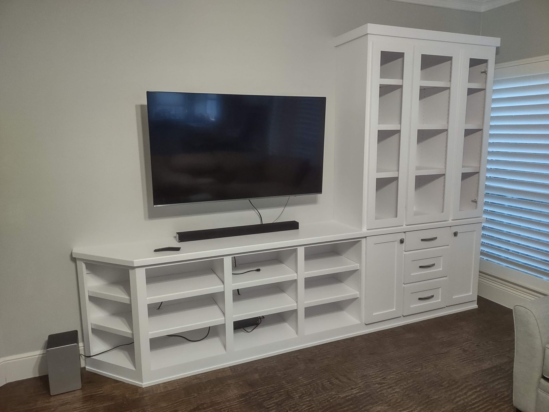 A living room with a flat screen tv on a white entertainment center.