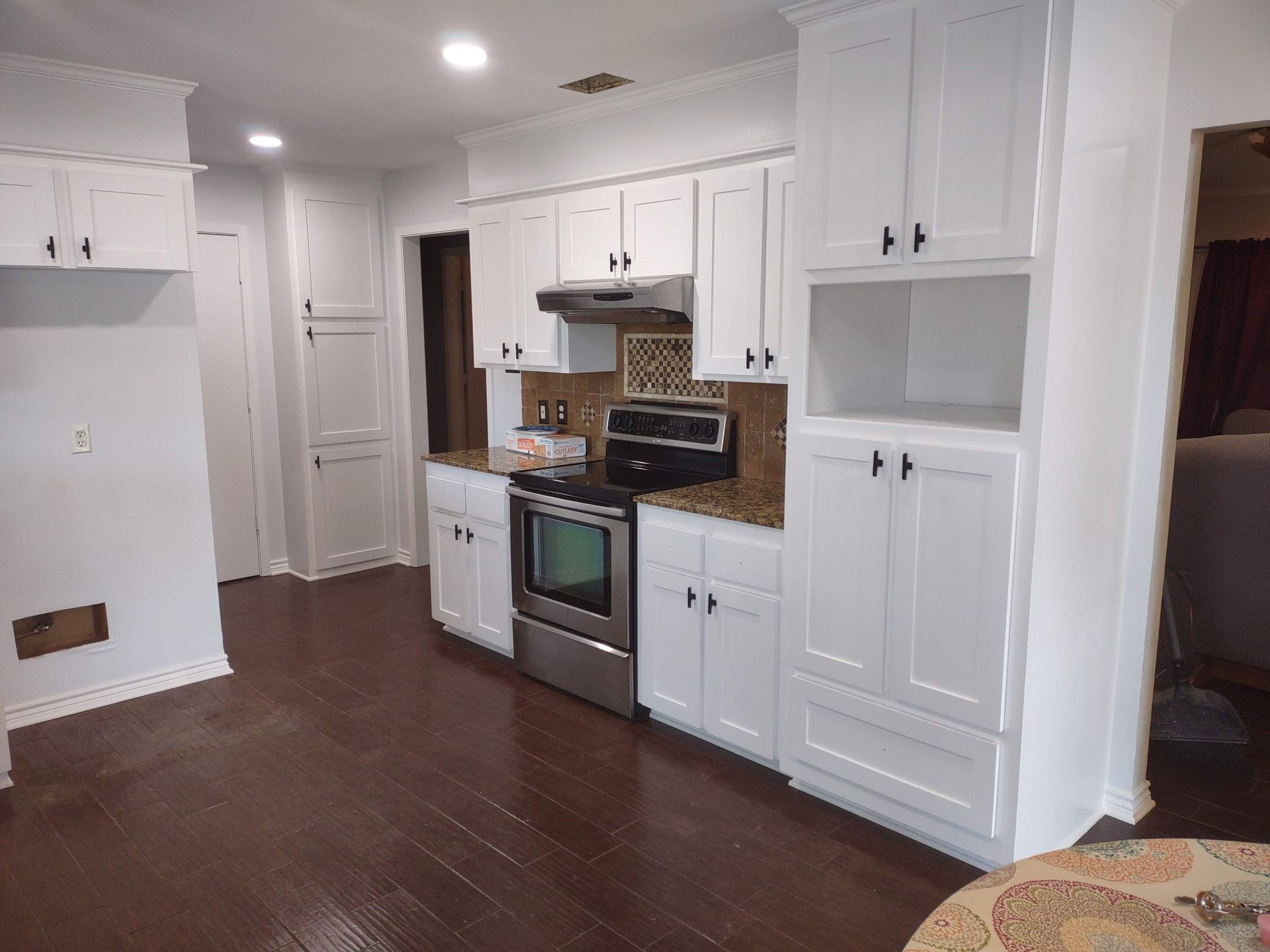 A kitchen with white cabinets and stainless steel appliances.