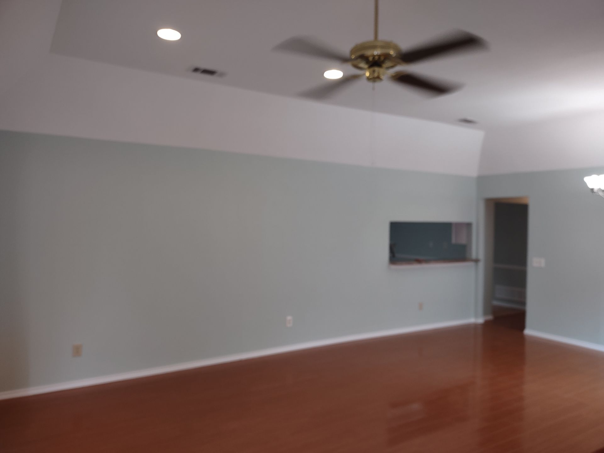 A living room with a ceiling fan hanging from the ceiling