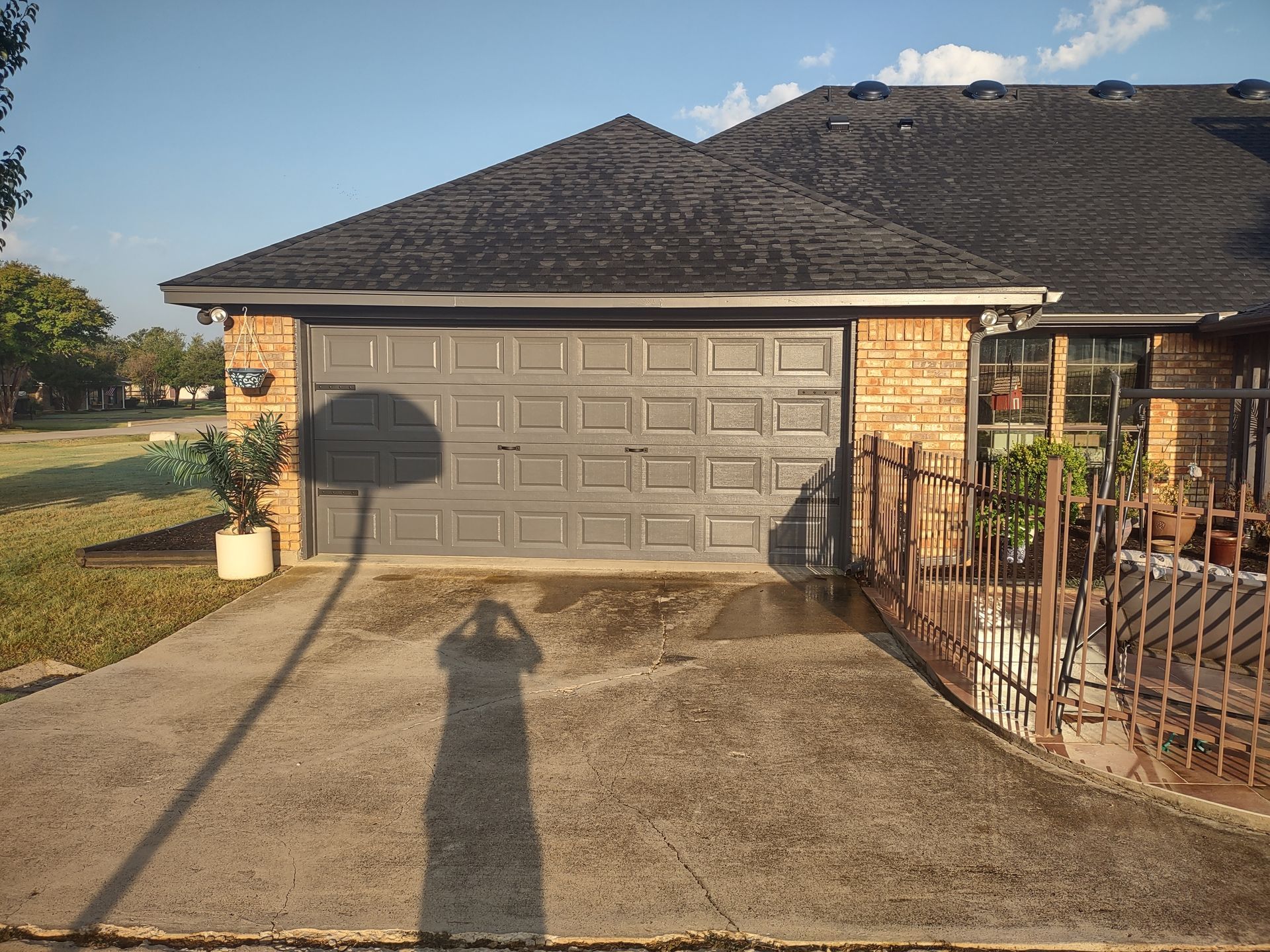 A brick house with a black roof and a garage door