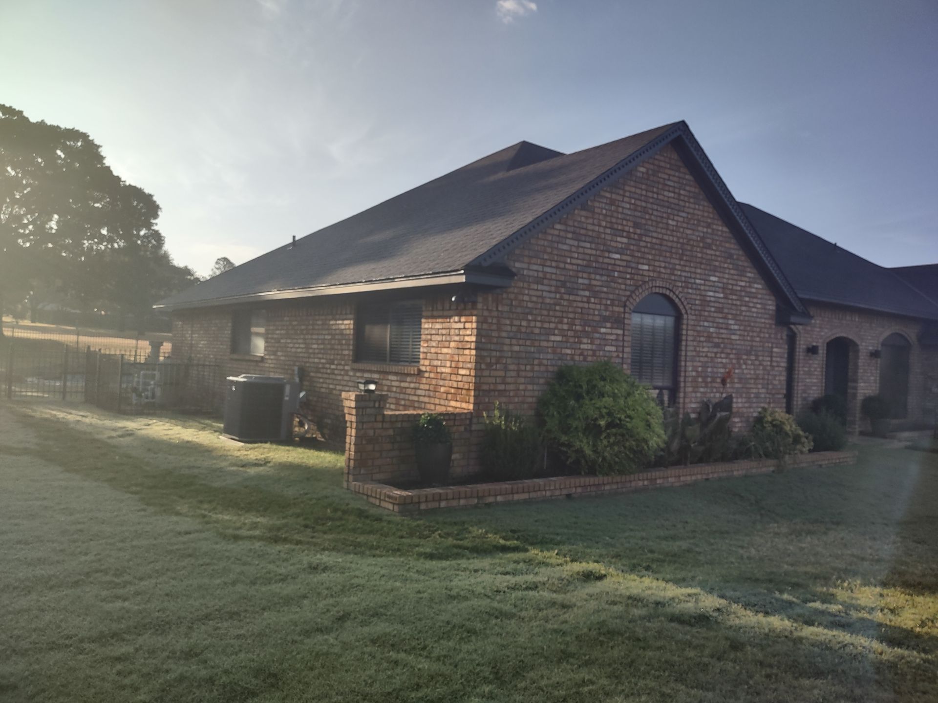 A brick house with a lush green lawn in front of it