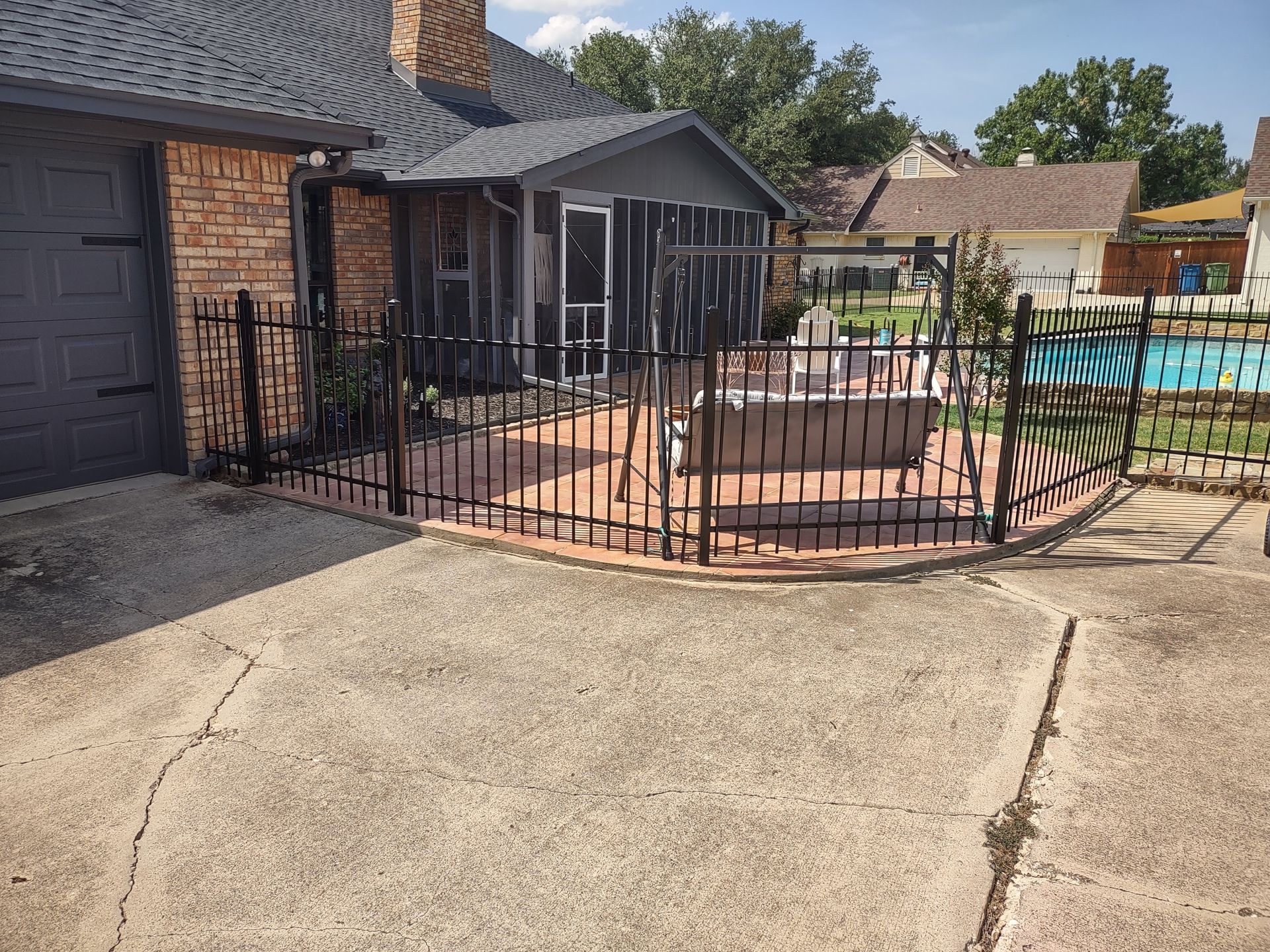 A house with a fence around it and a pool in the backyard.
