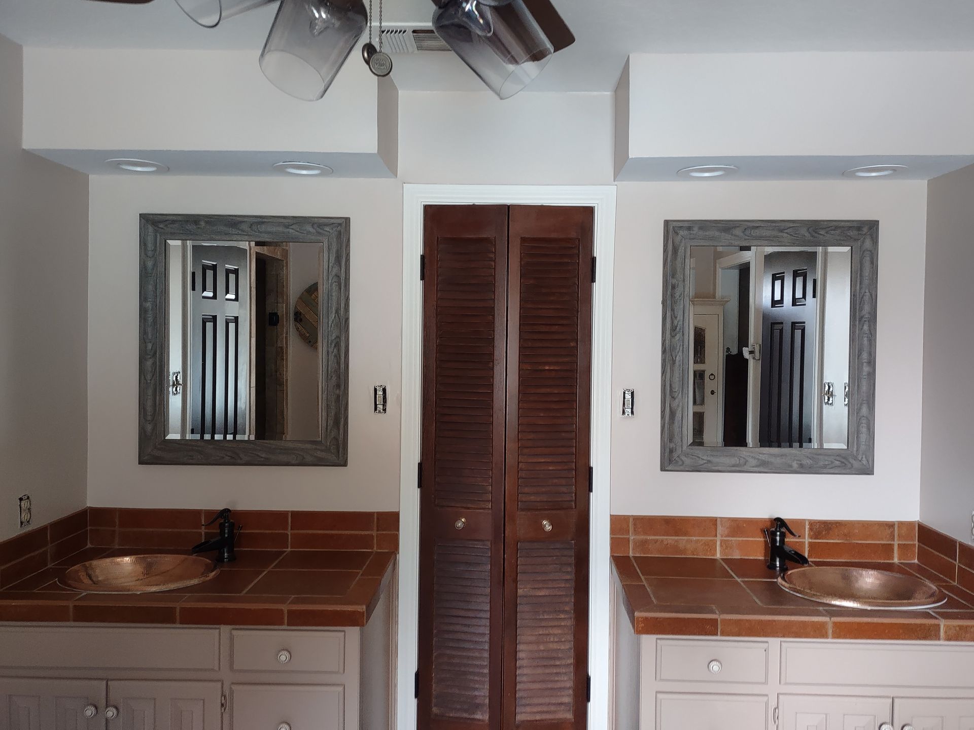 A bathroom with two sinks and two mirrors