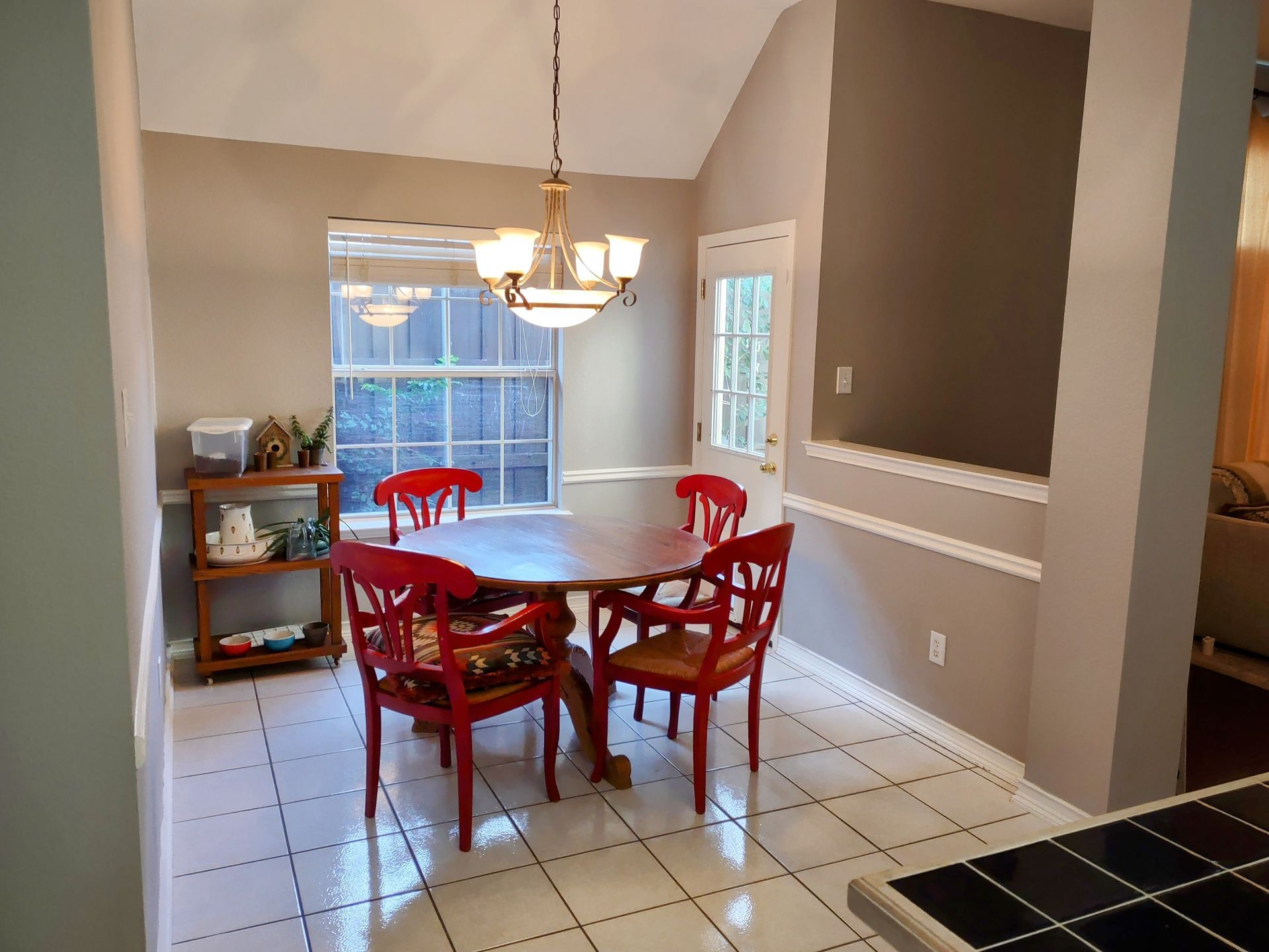 A dining room with a round table and red chairs