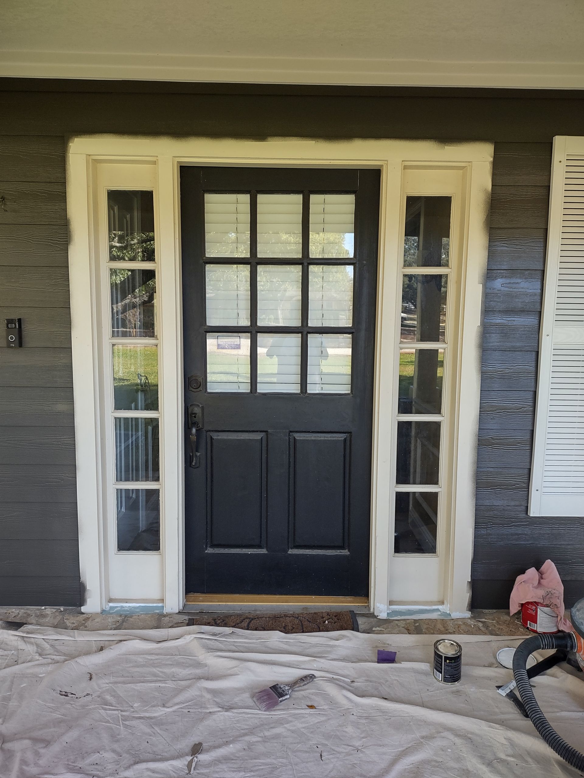 The front door of a house is being painted black and white.