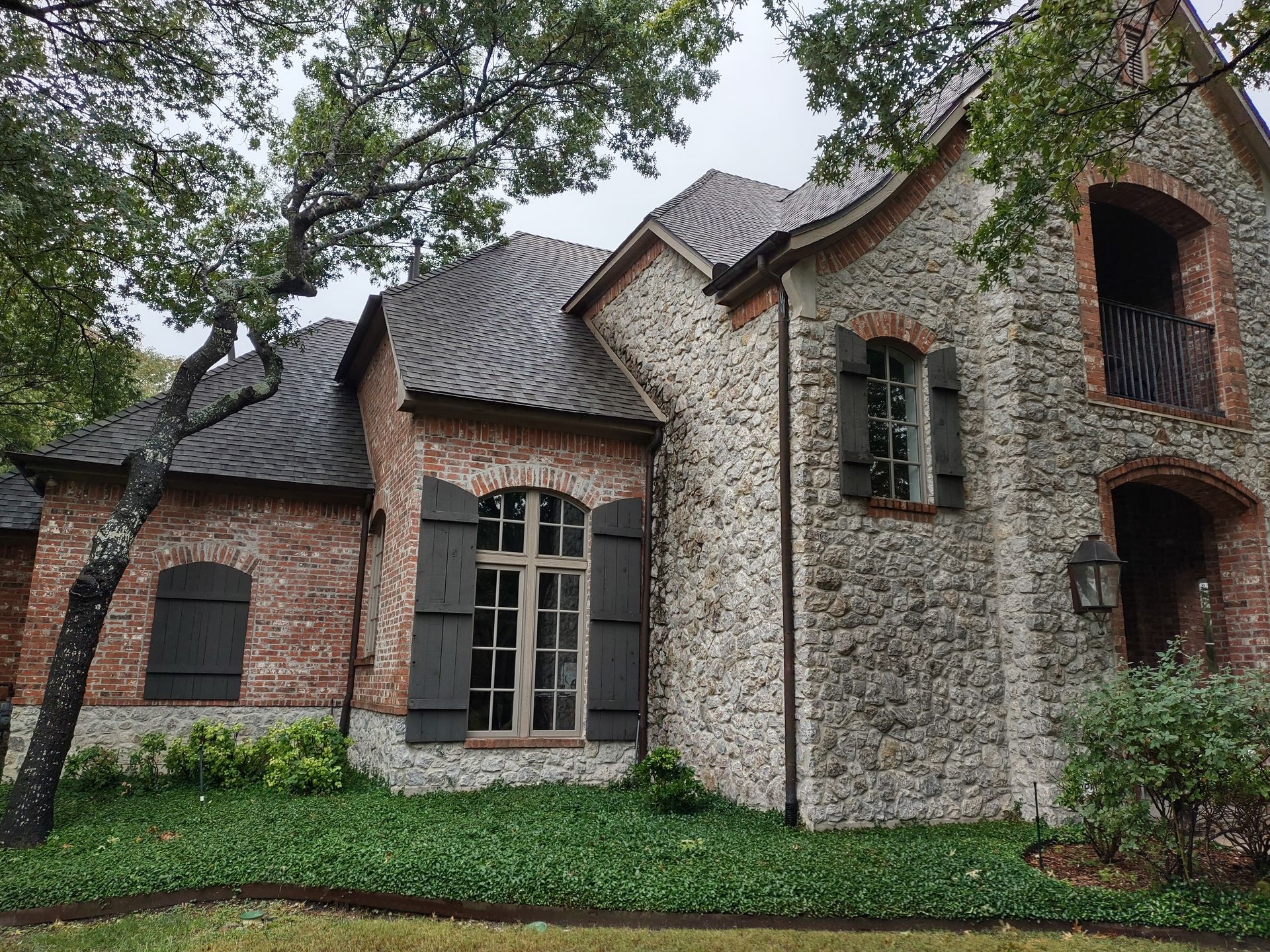 A large brick house with black shutters on the windows