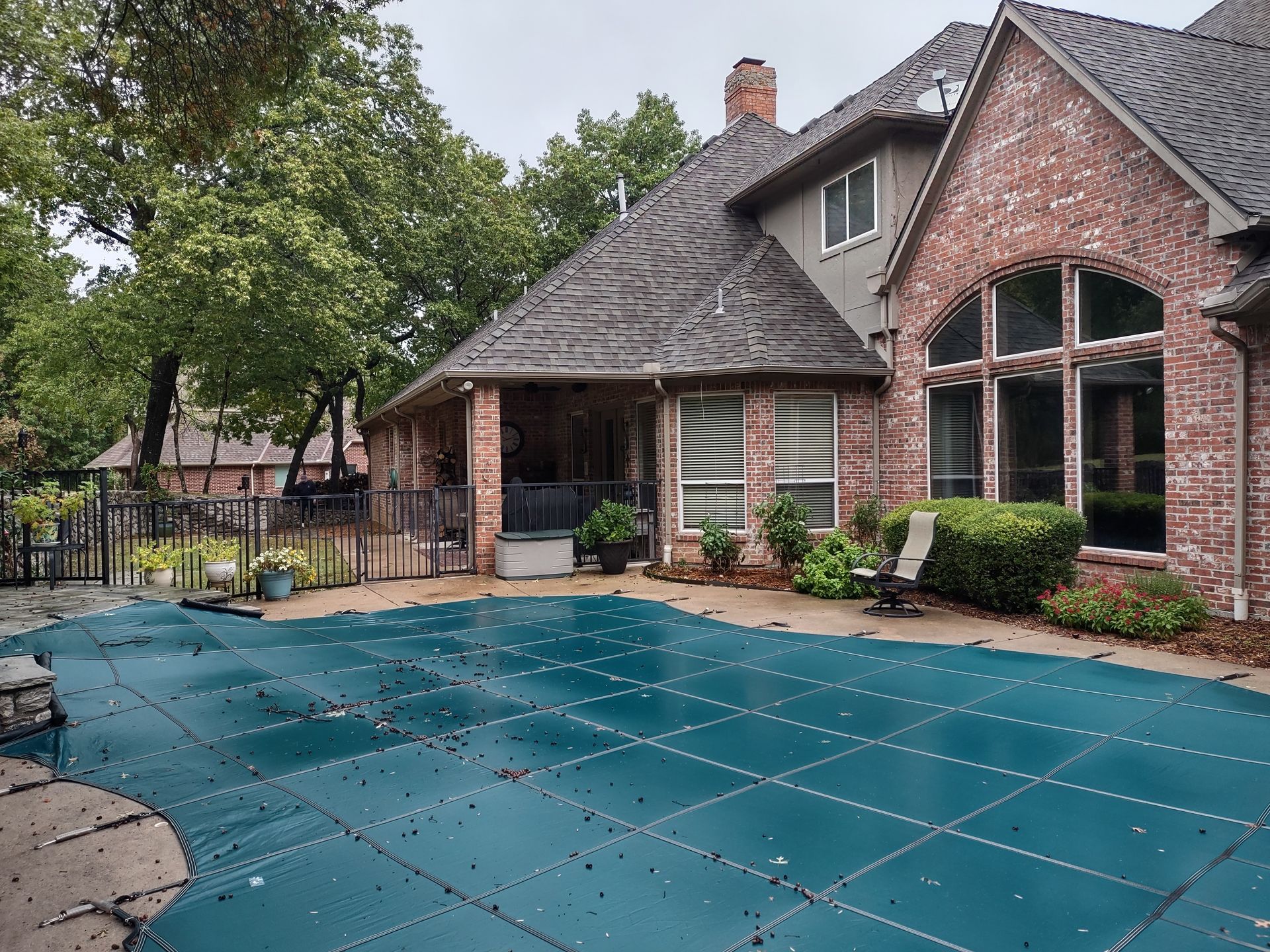 A large brick house with a swimming pool in front of it.