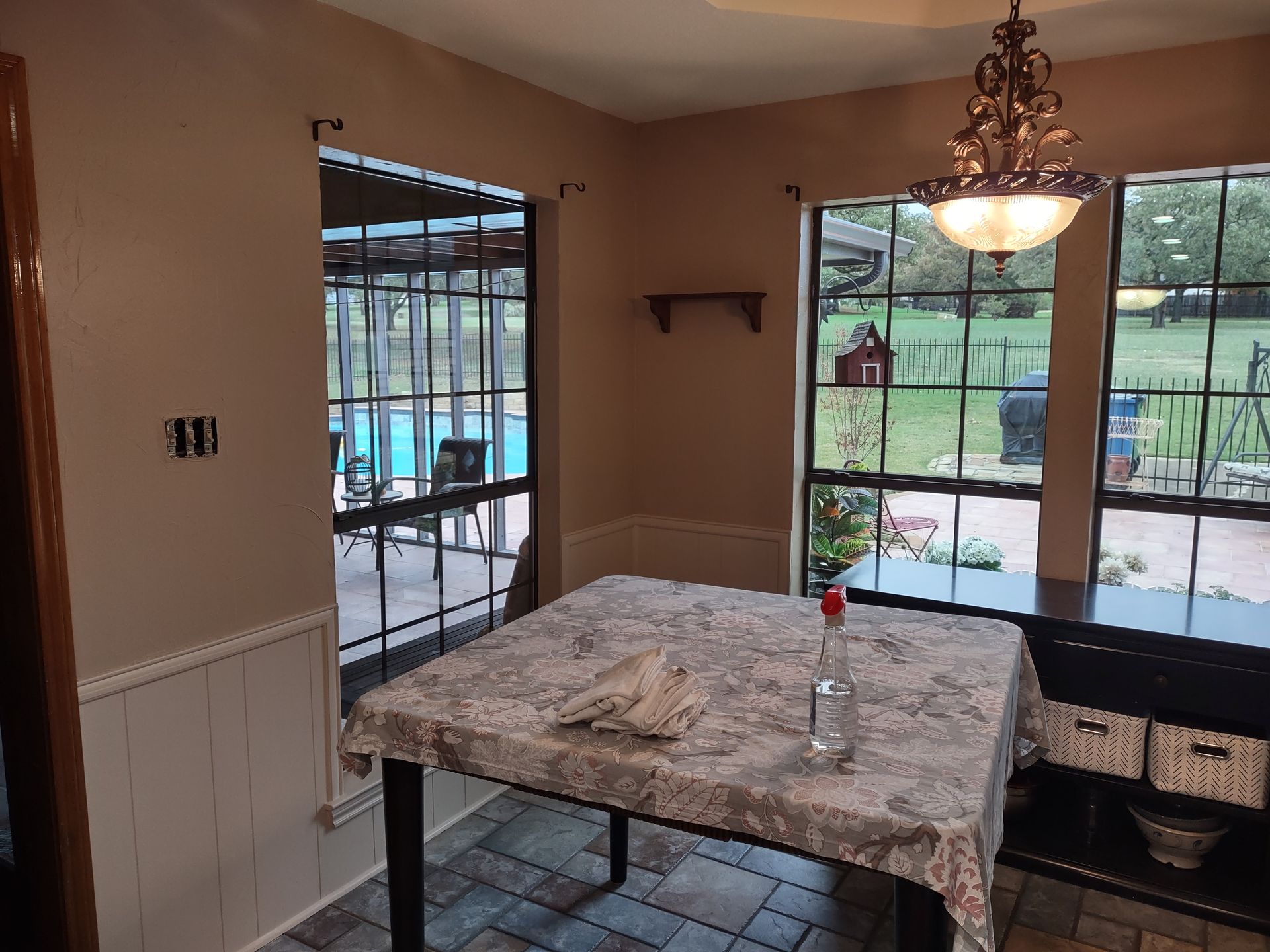 A dining room with a table and a chandelier.
