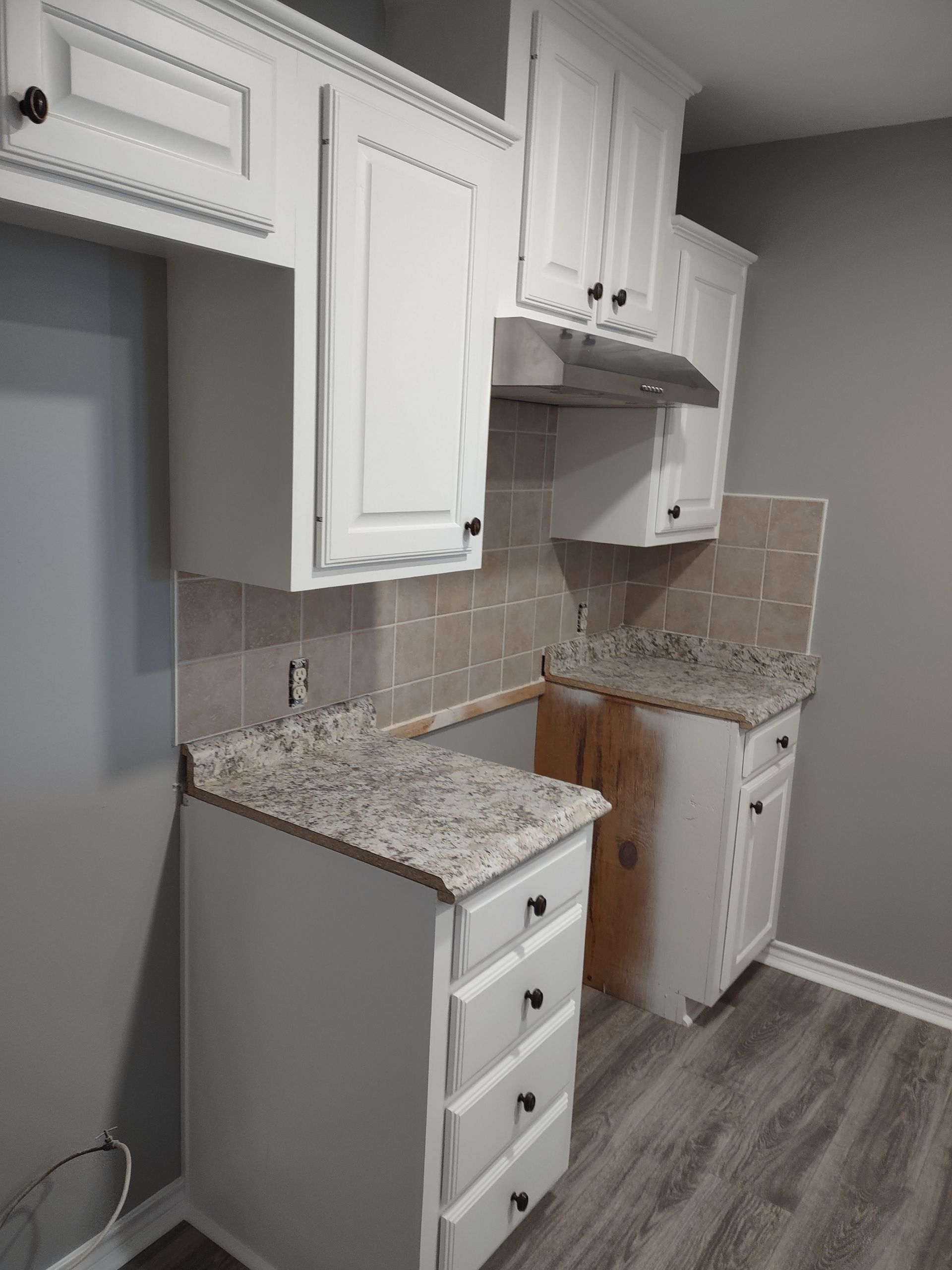 A kitchen with white cabinets and granite counter tops