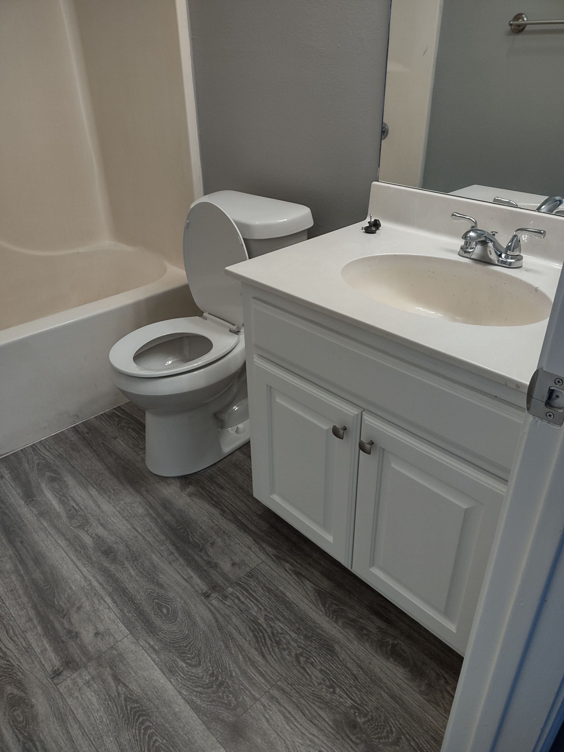 A bathroom with a toilet , sink and bathtub.