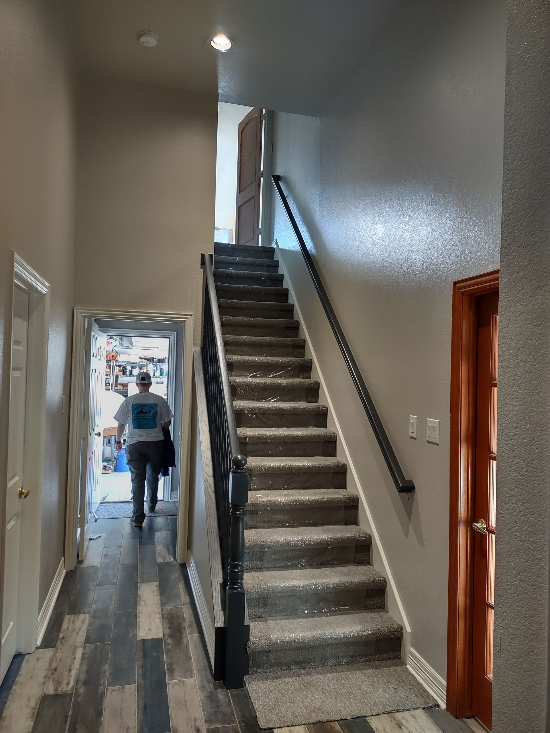 A man is walking down a set of stairs in a hallway.