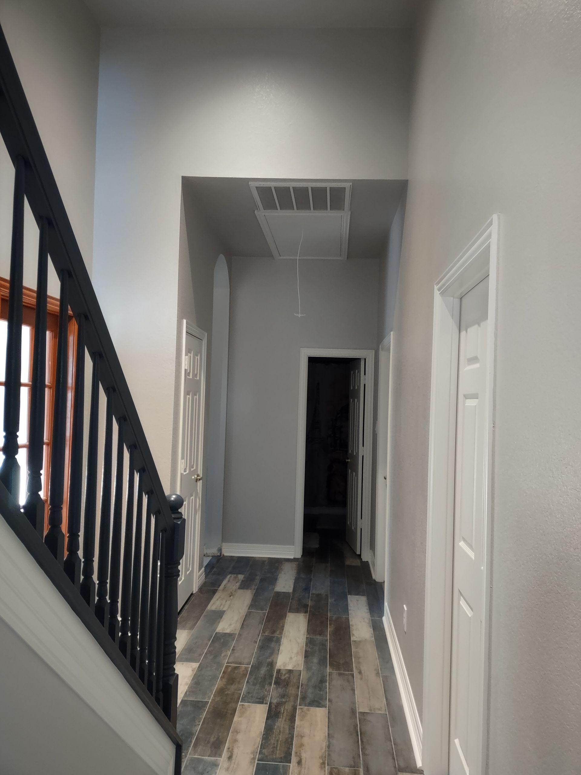 A hallway with stairs leading up to the second floor