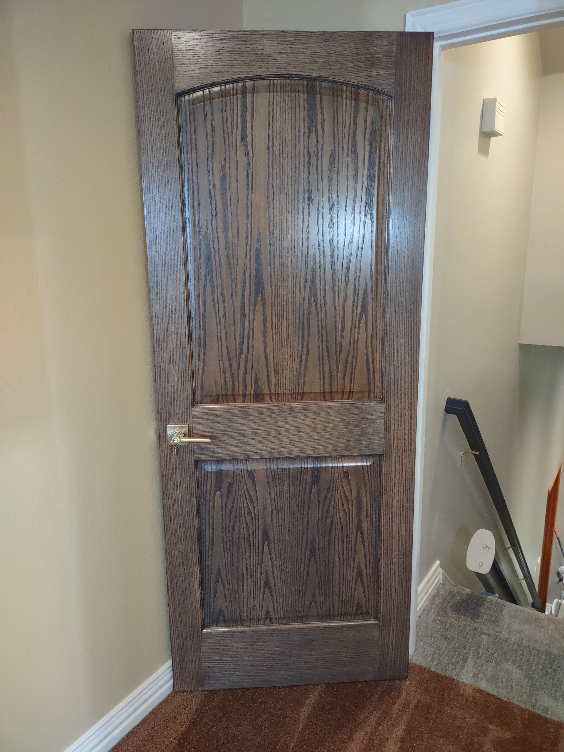 A wooden door in a room next to a staircase