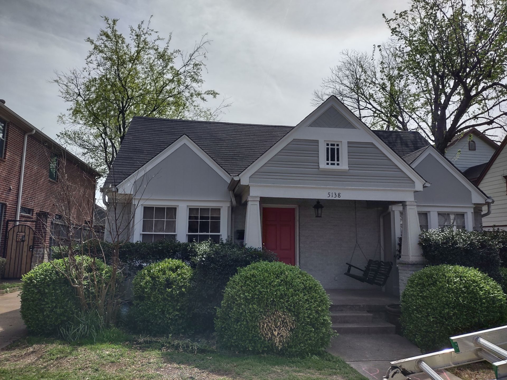 A house with a red door and a ladder in front of it