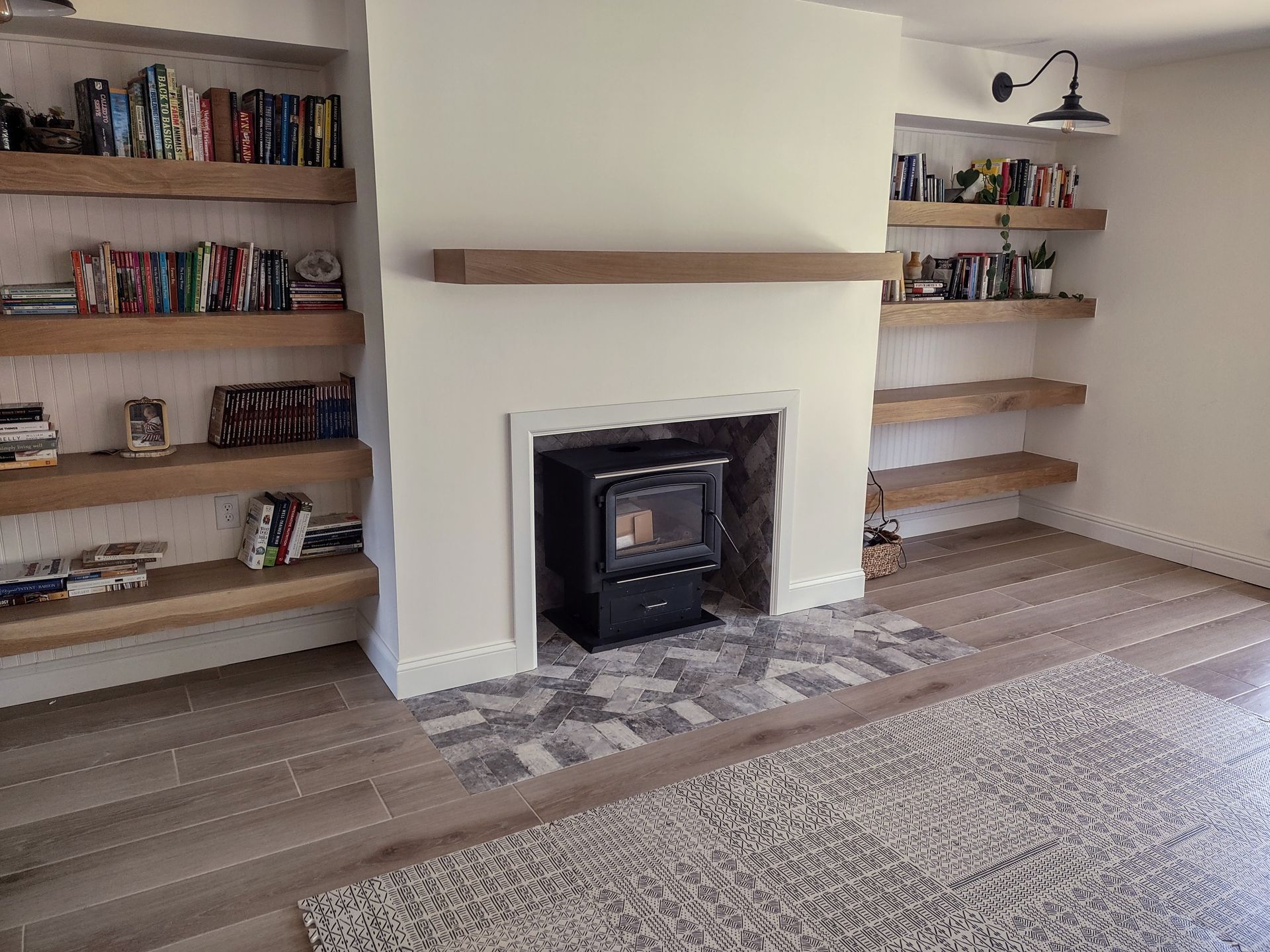 A living room with a fireplace and shelves filled with books.