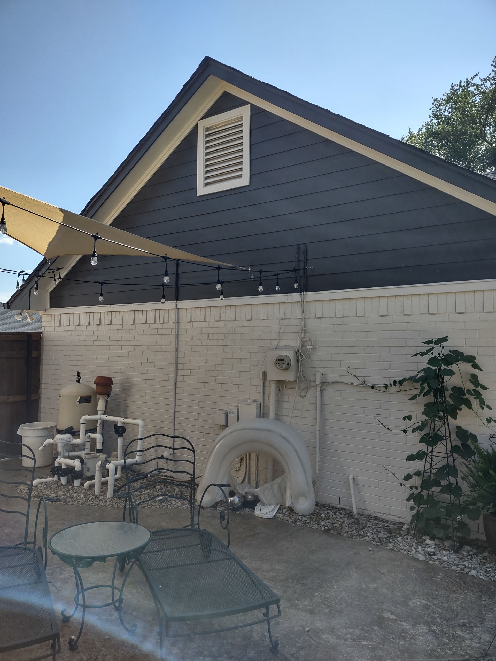 A patio area with a table and chairs in front of a house