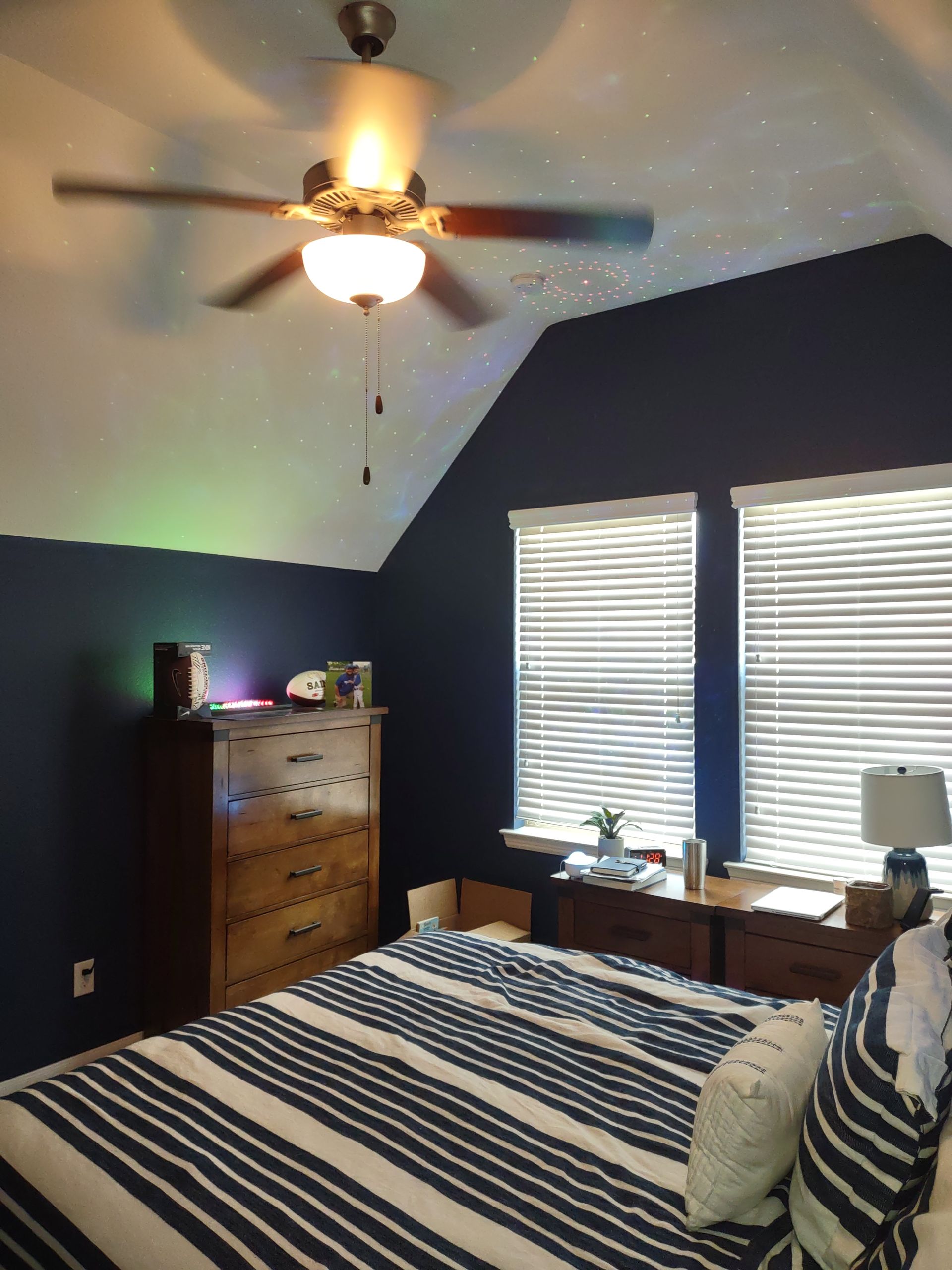 A bedroom with a bed and a ceiling fan