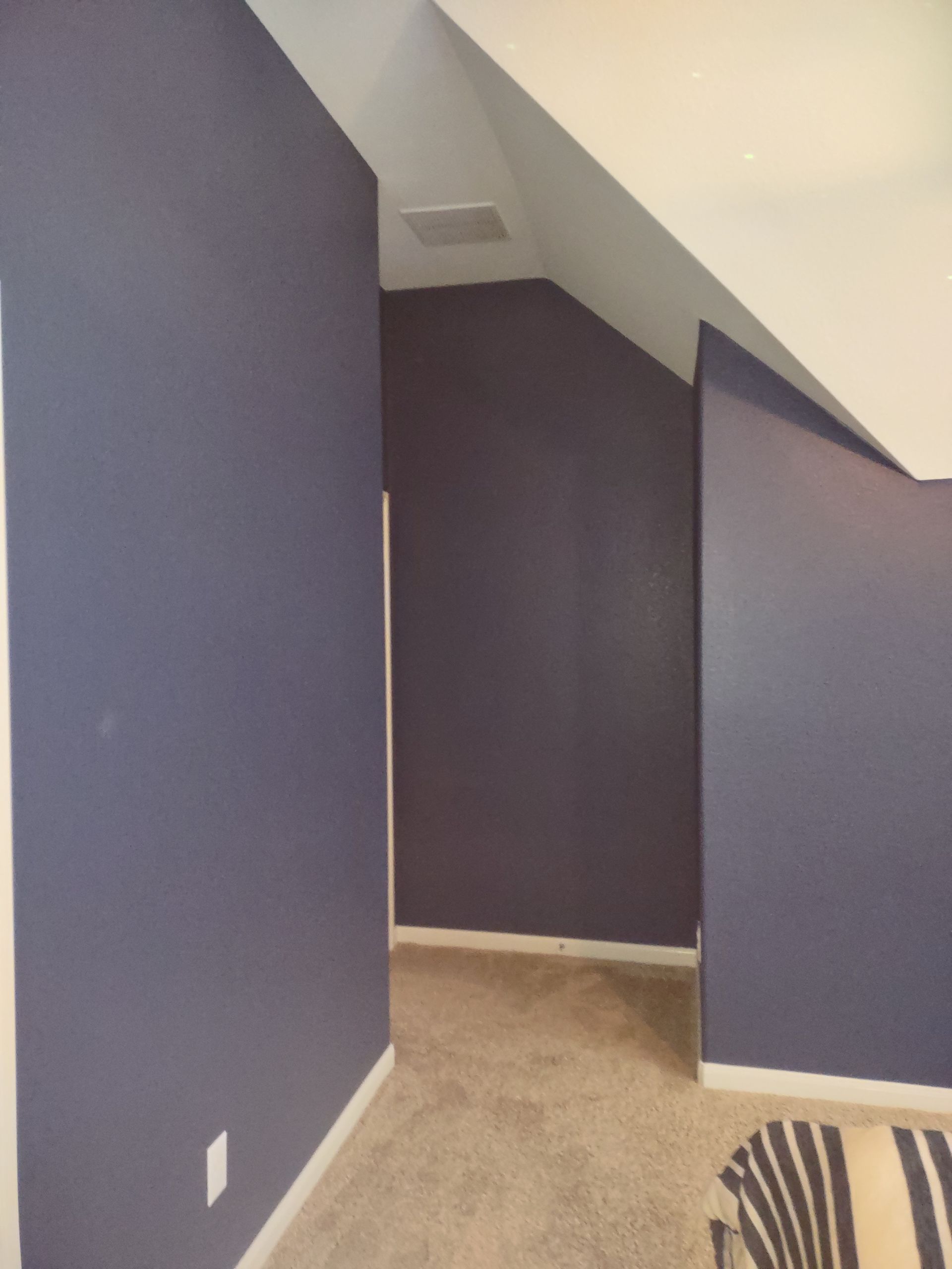 A room with purple walls and a striped chair