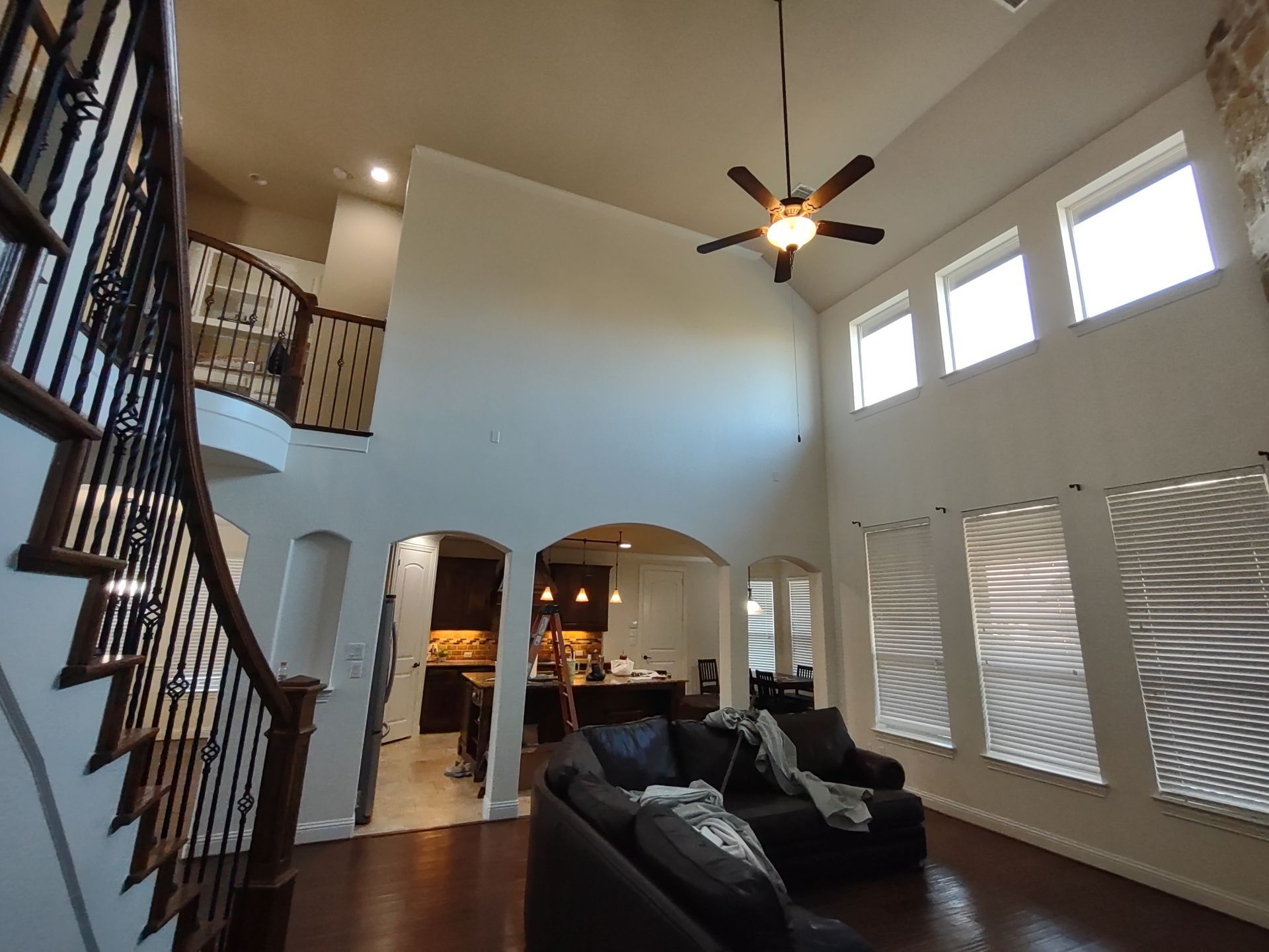 A living room with a staircase and a ceiling fan