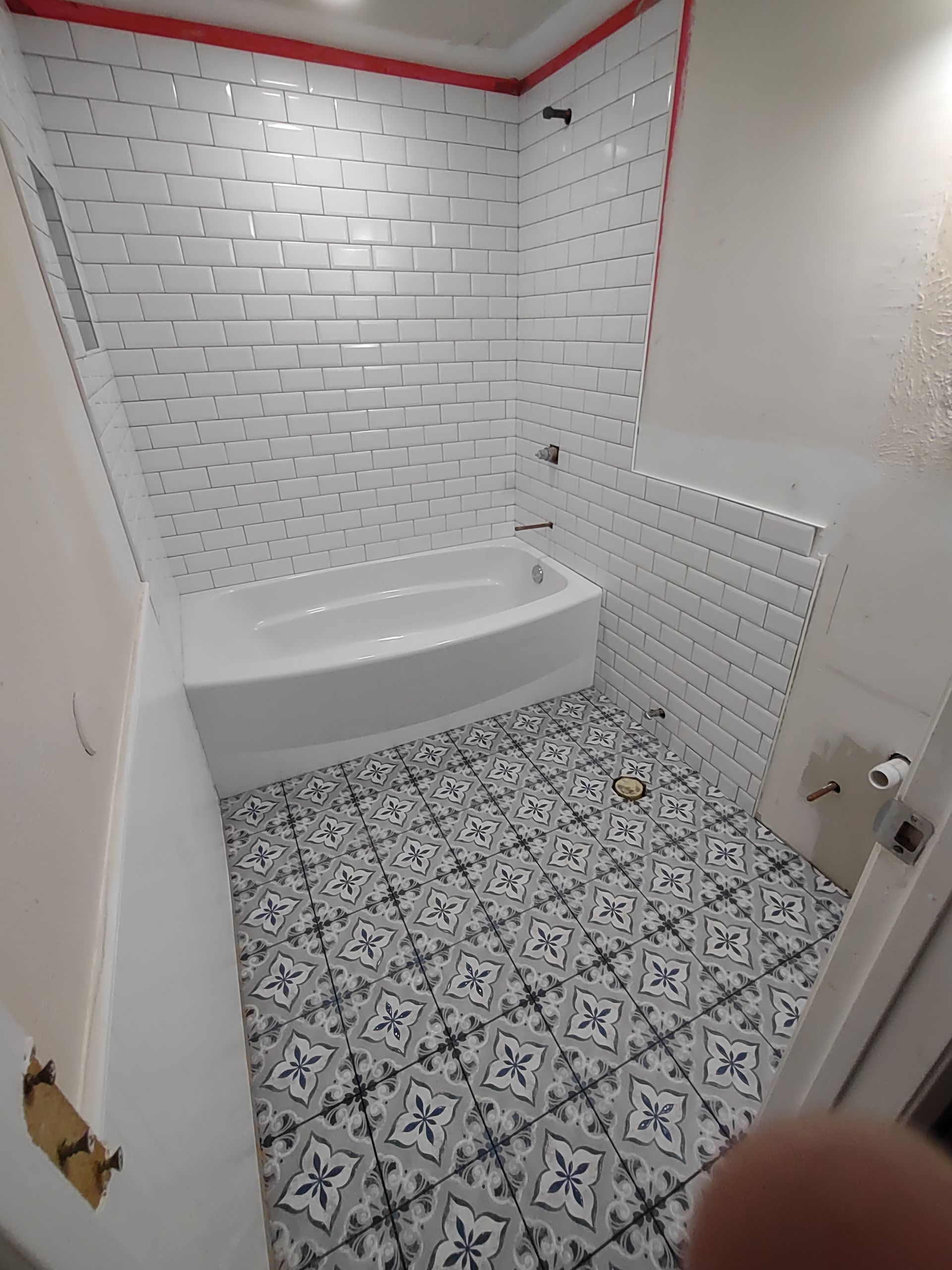 A bathroom with a bathtub and a tiled floor