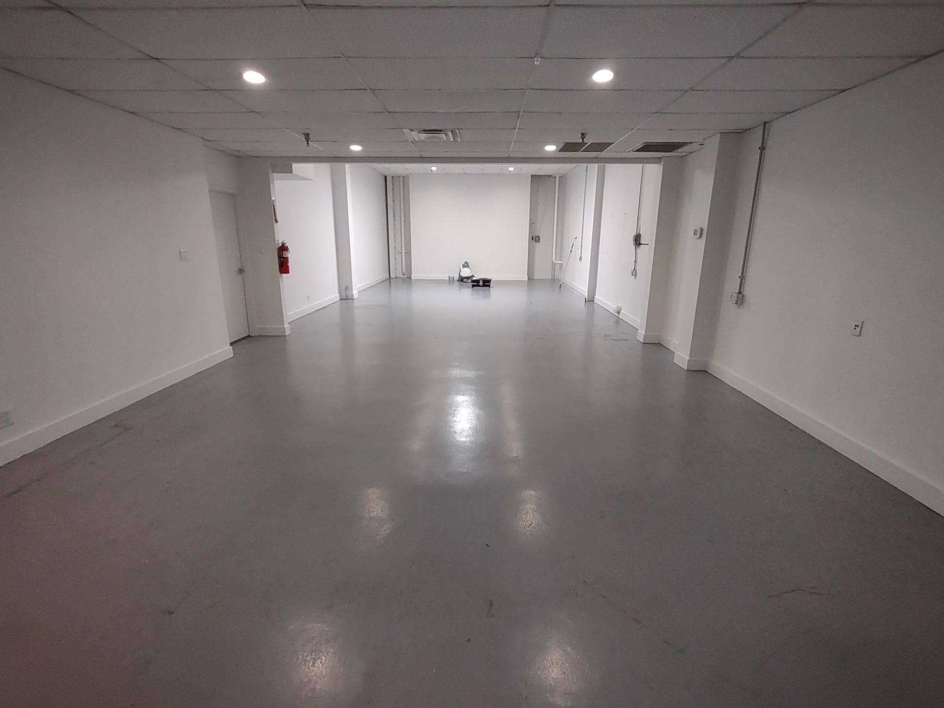 A large empty room with a gray floor and white walls
