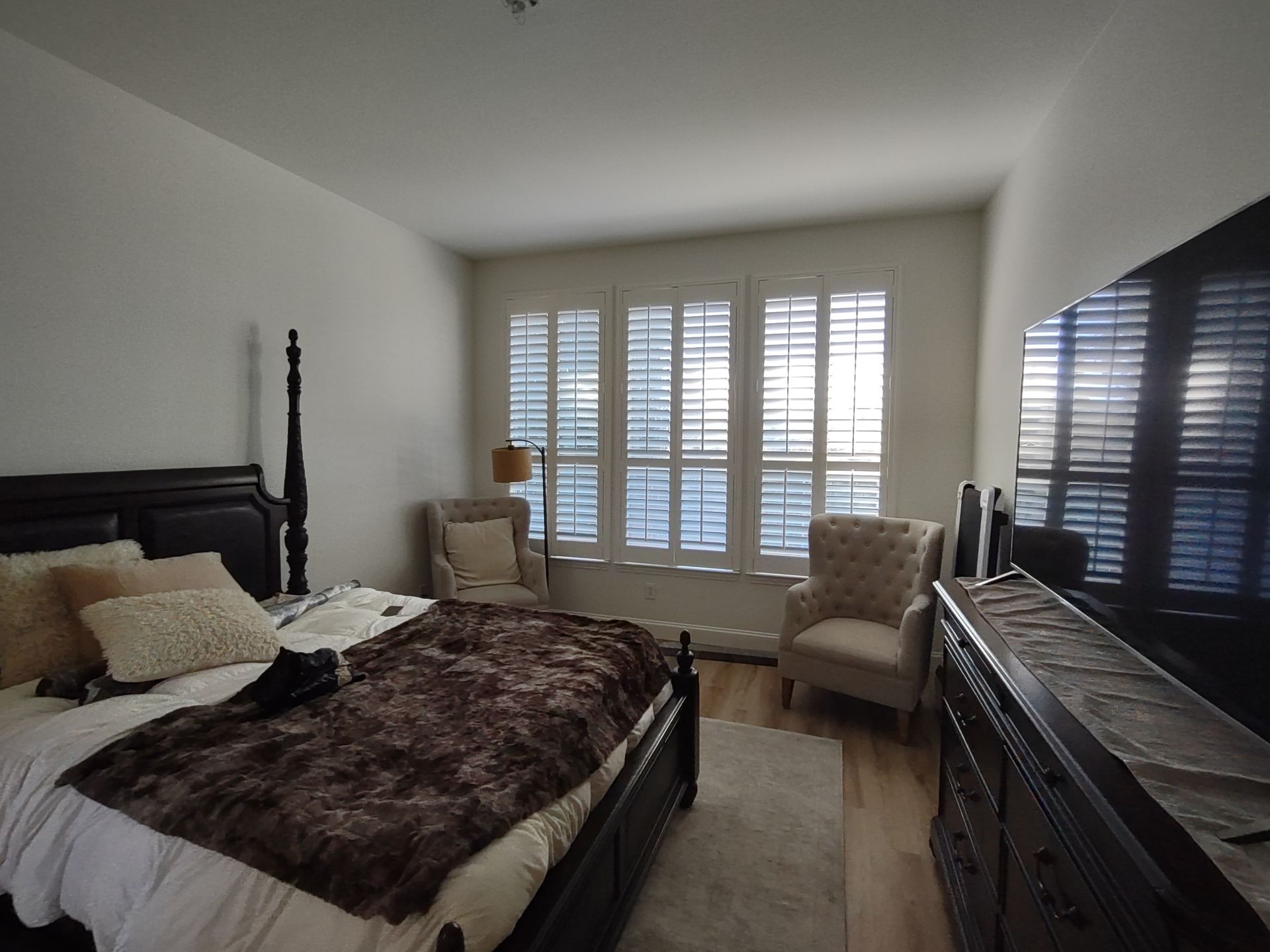 A bedroom with a large bed and a television