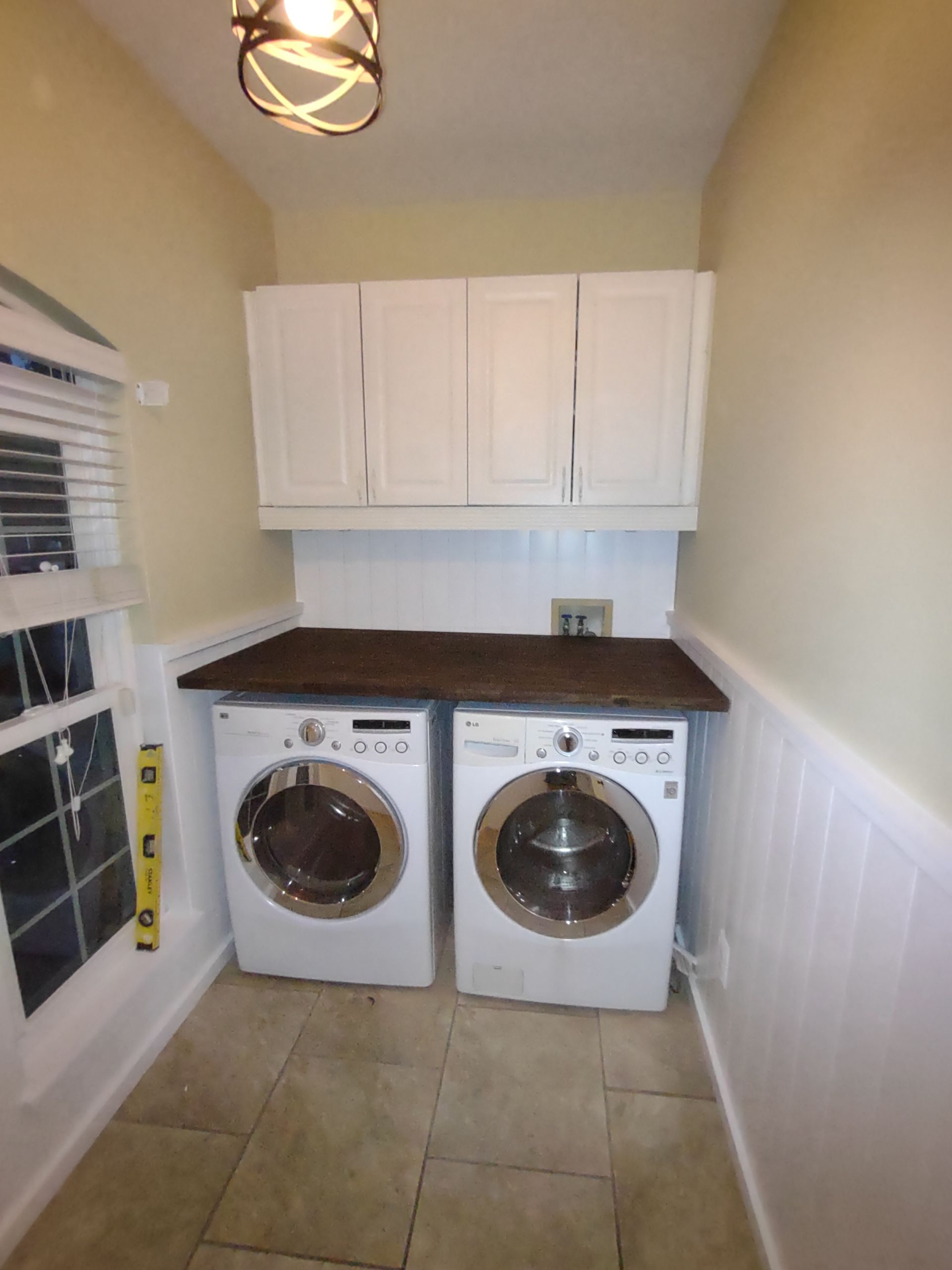 A laundry room with two washers and two dryers
