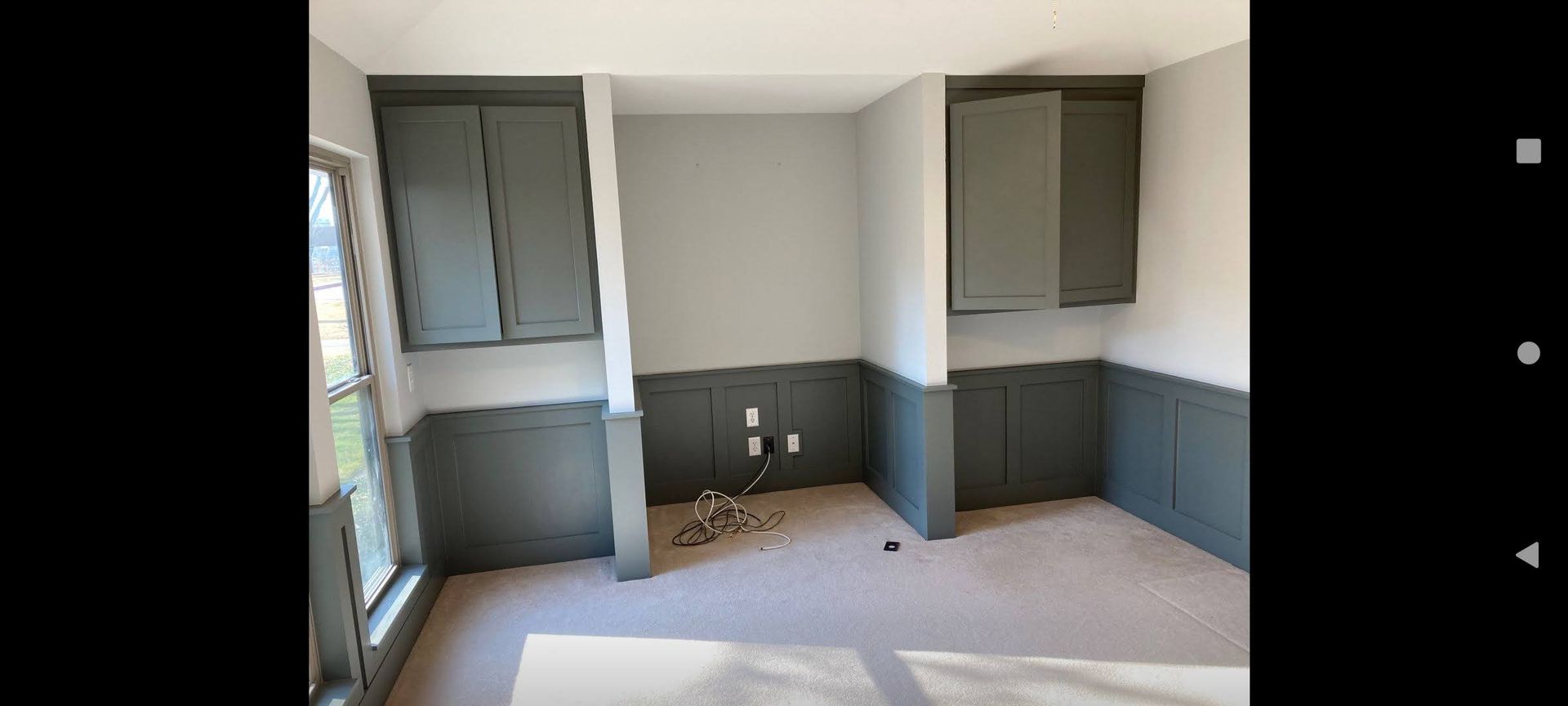 A room with a lot of cabinets and a window.