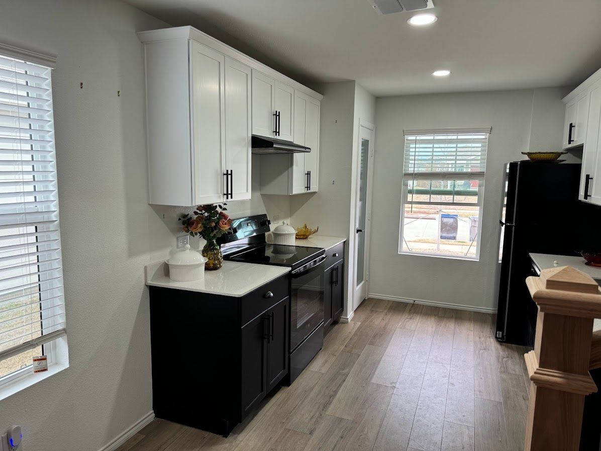 A kitchen with black appliances and white cabinets