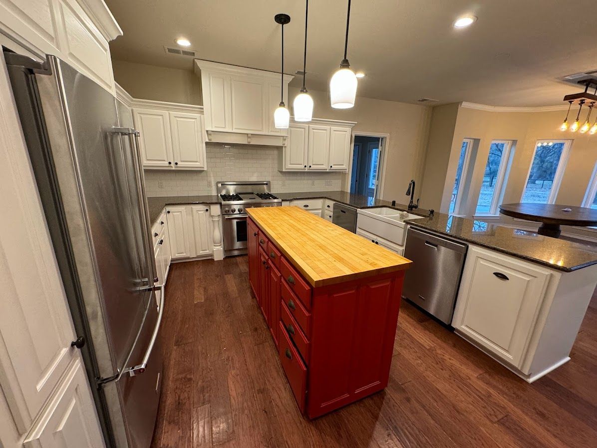 A kitchen with stainless steel appliances and a large red island.