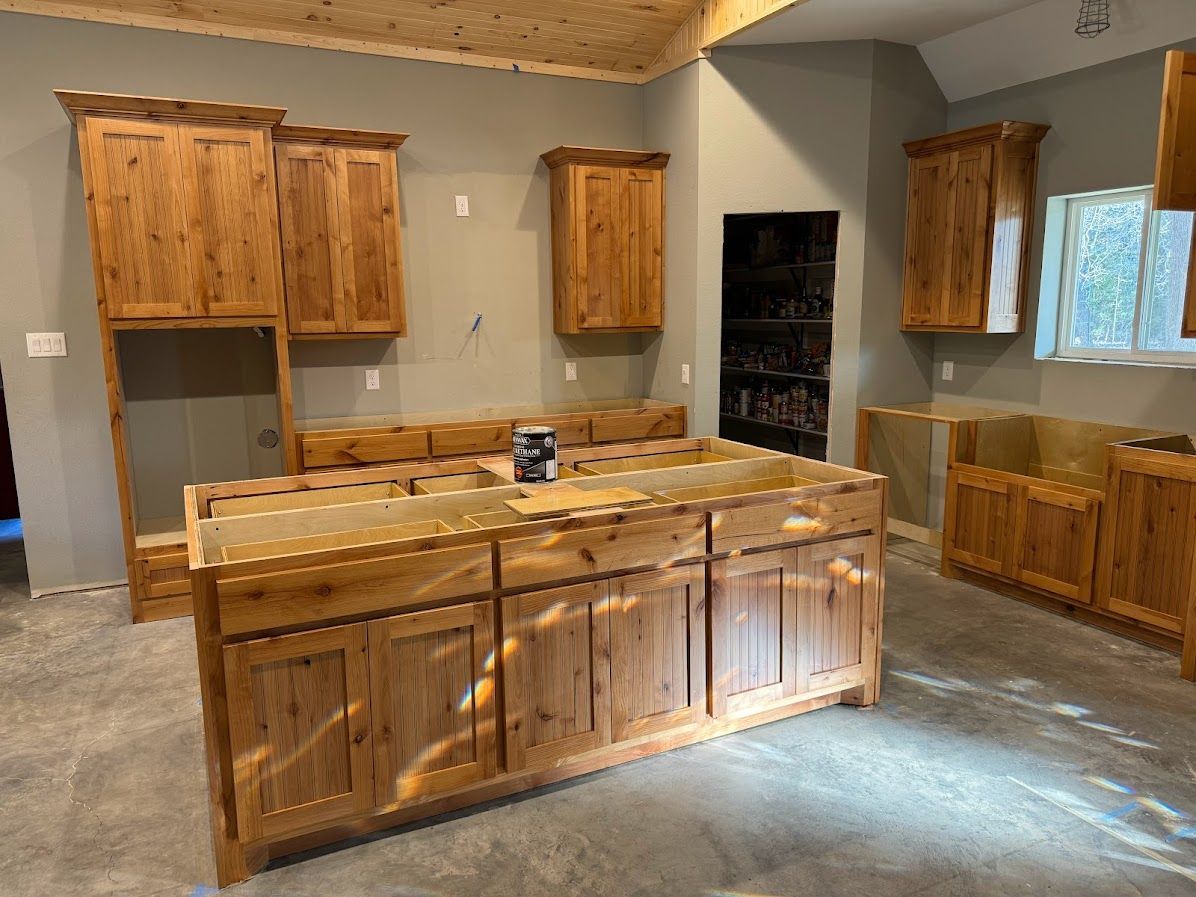 A kitchen with wooden cabinets and a large island in the middle of the room.