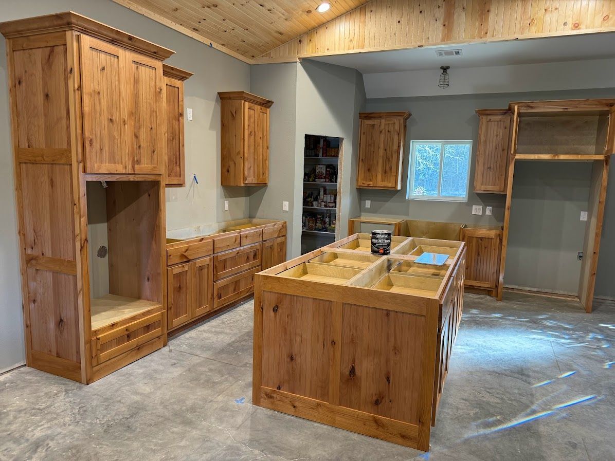 A kitchen with wooden cabinets and a large island in the middle.