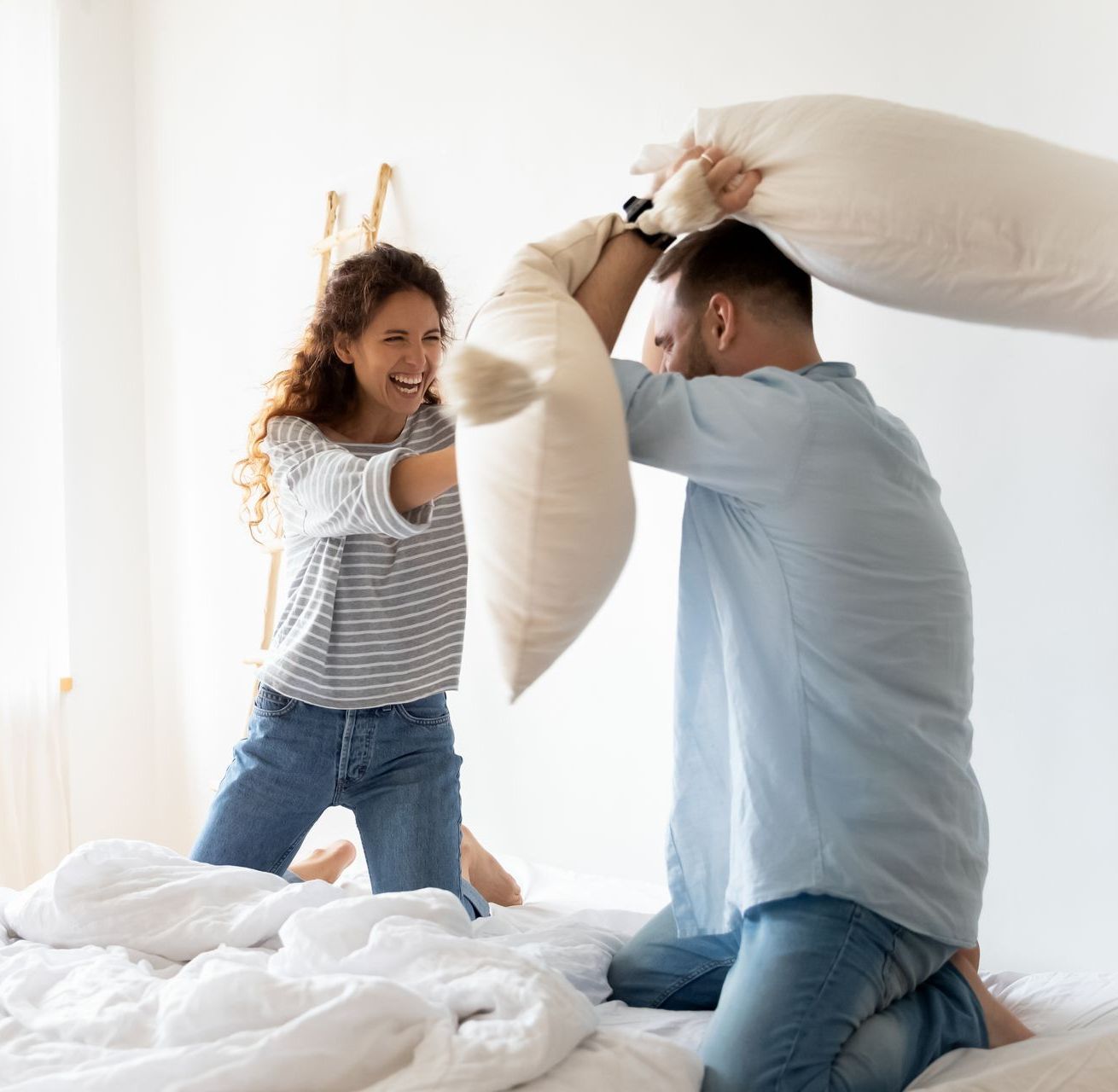 The same couple from above is shown having a friendly pillow fight, they are comfortable with one another because they know the importance of date night