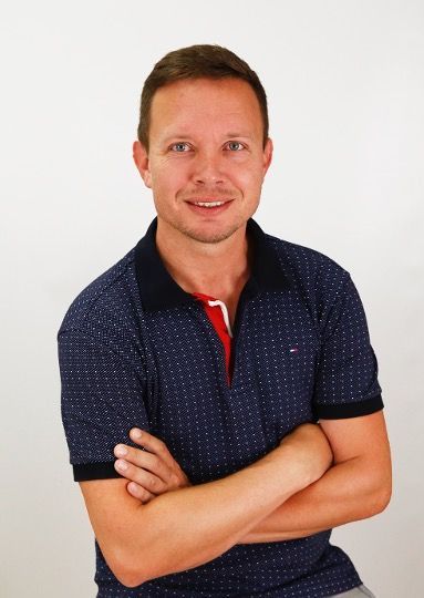 Ein Mann in einem blauen Hemd mit verschränkten Armen