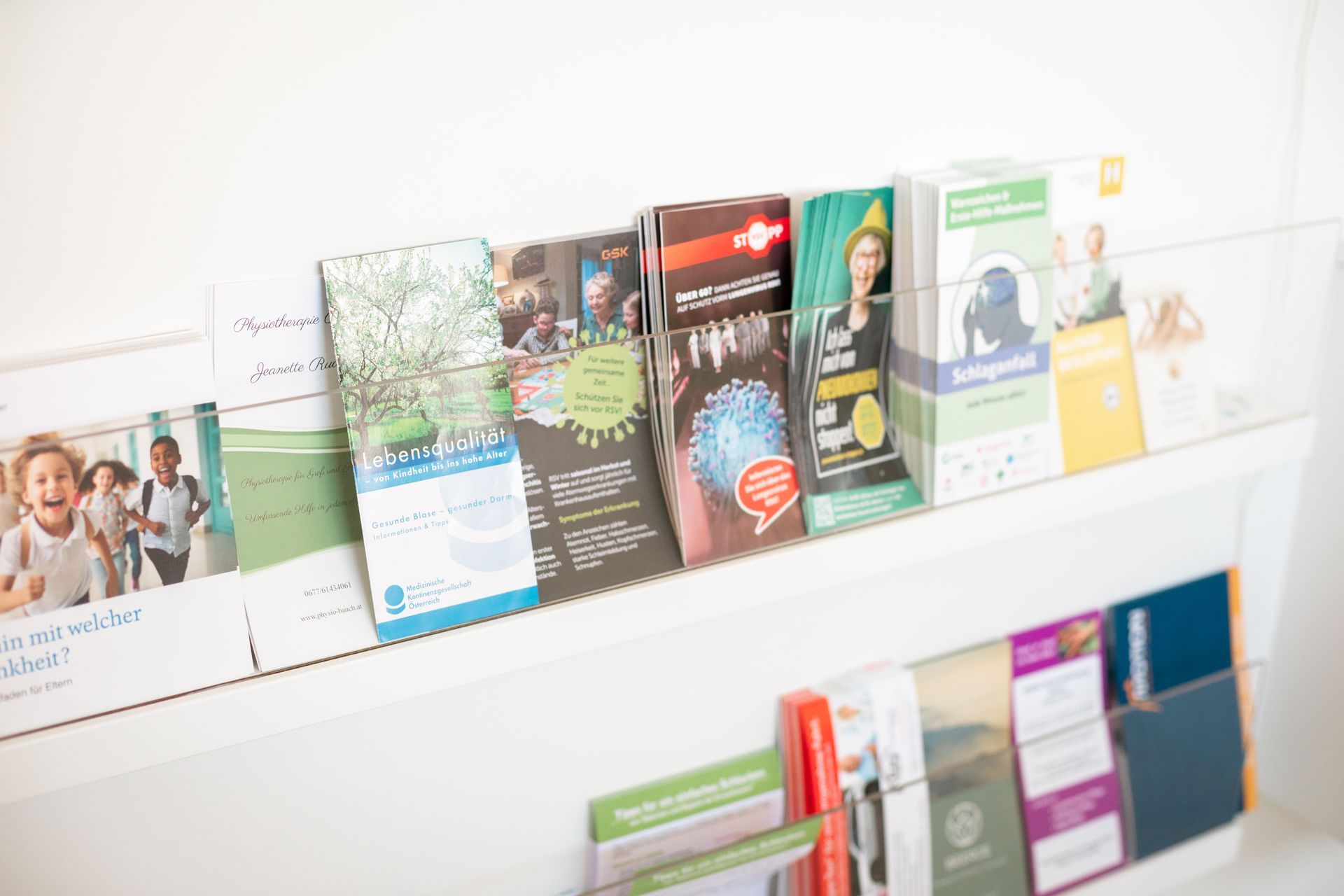 An einer Wand hängt ein Regal voller Broschüren und Prospekte.
