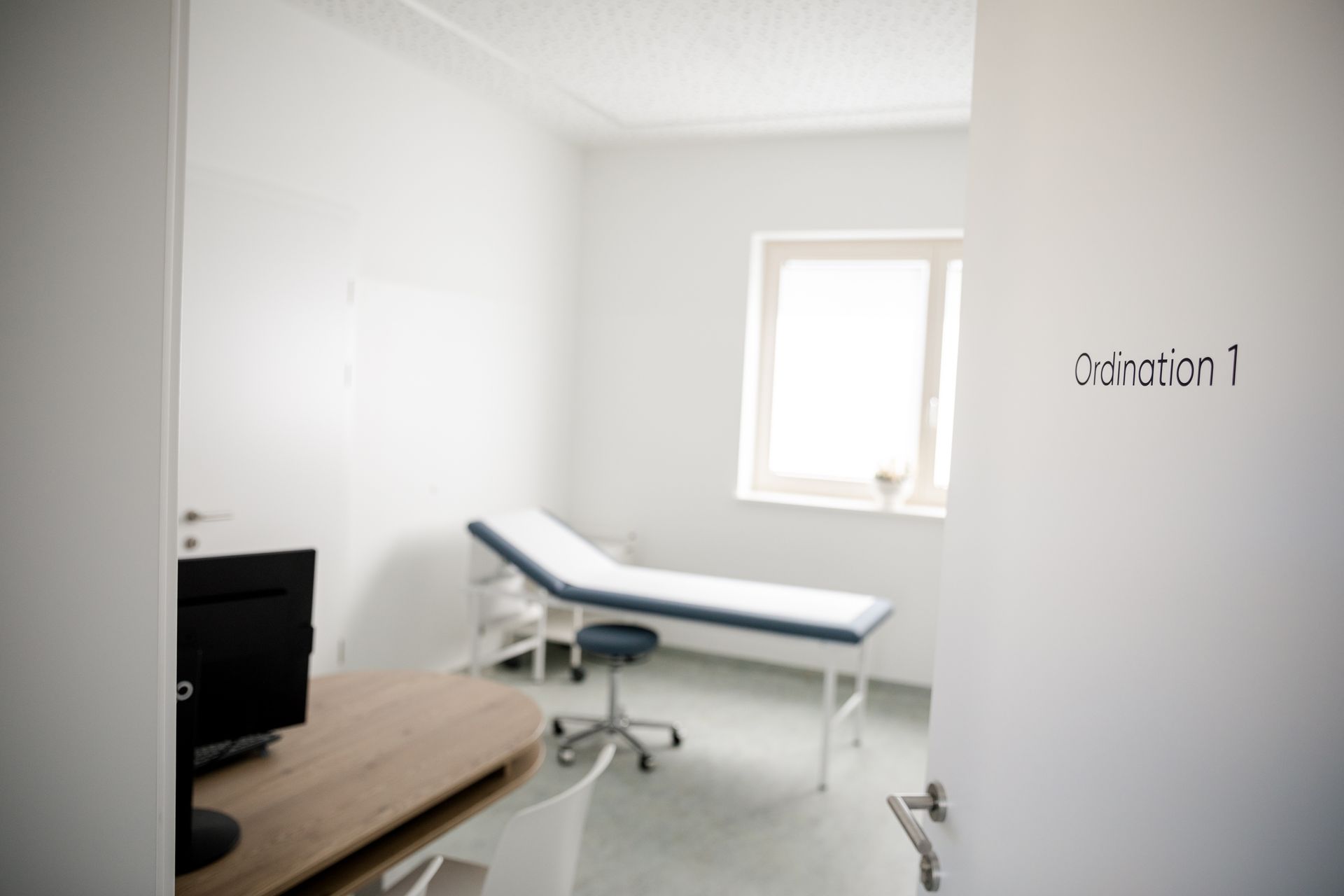 Eine Arztpraxis mit einem Schreibtisch und einem Bett und einer Tür, auf der „Erklärung 1“ steht