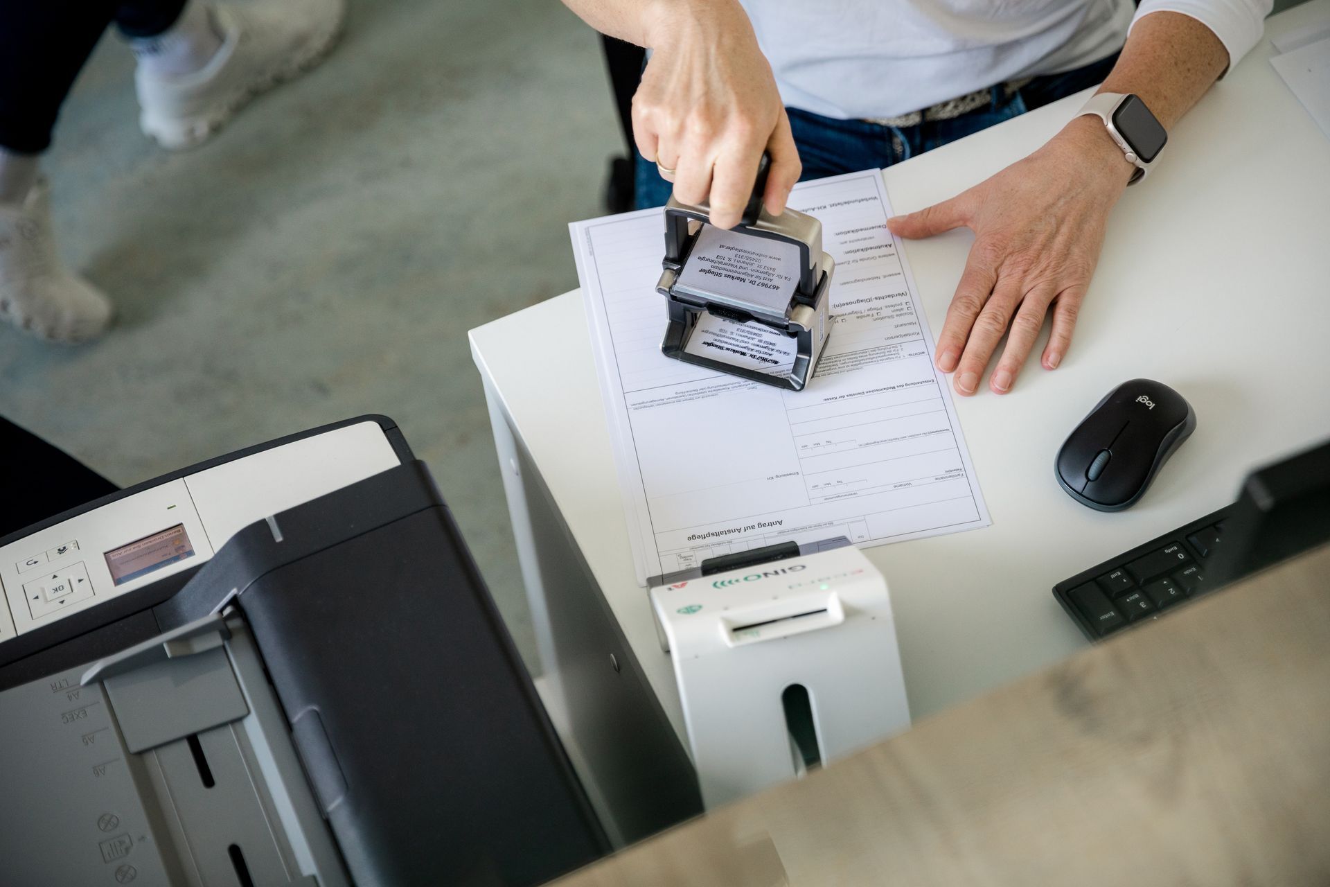 Eine Frau drückt einen Stempel auf ein Stück Papier.