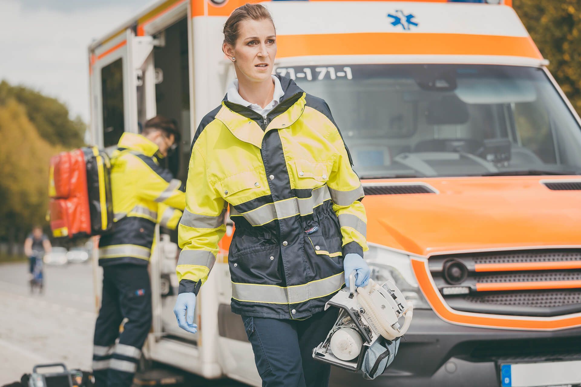 A female paramedic is walking towards an ambulance