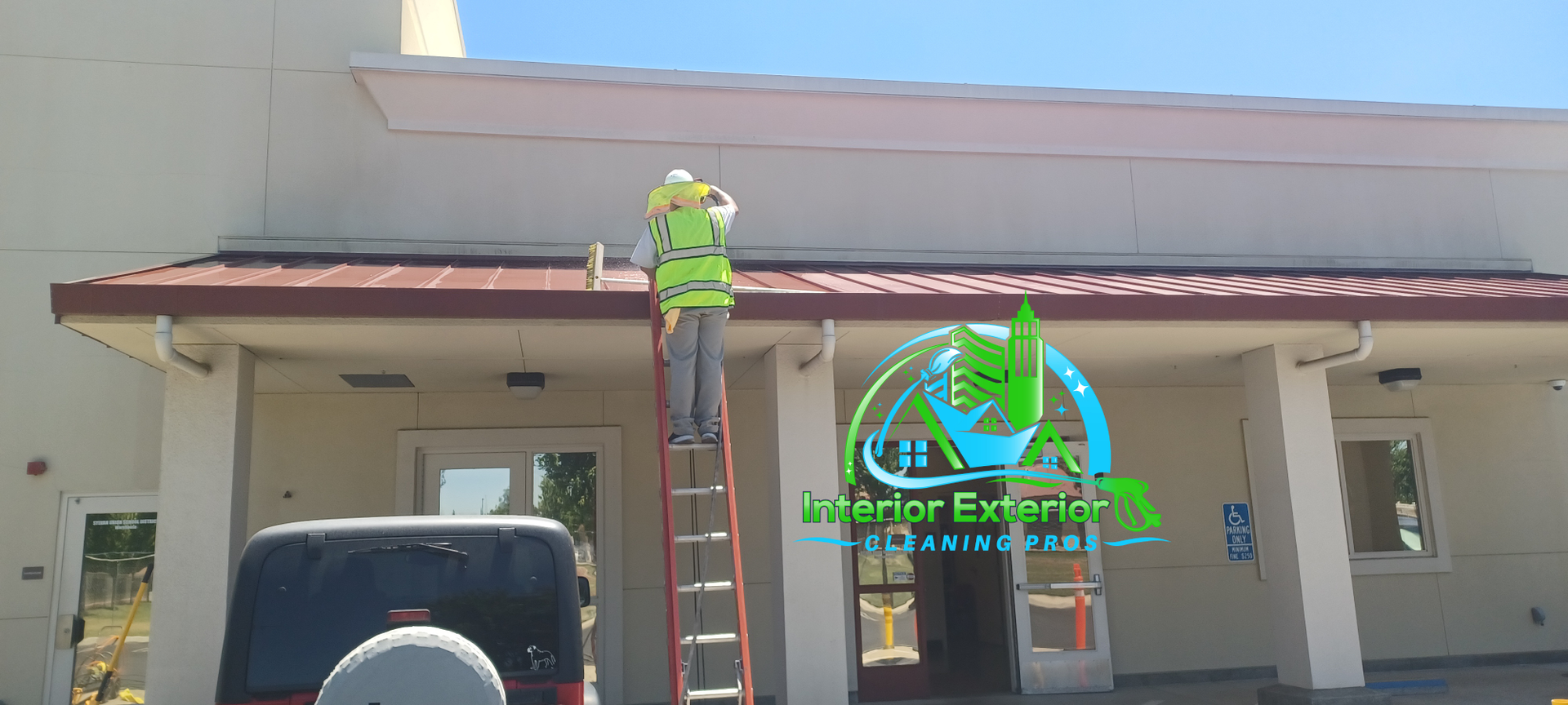 A man on a ladder is painting the roof of a building.