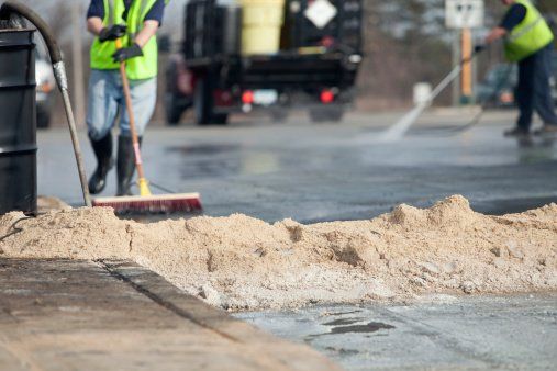 A man is sweeping the ground with a broom.