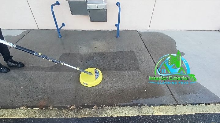 A person is cleaning a sidewalk with a yellow disc