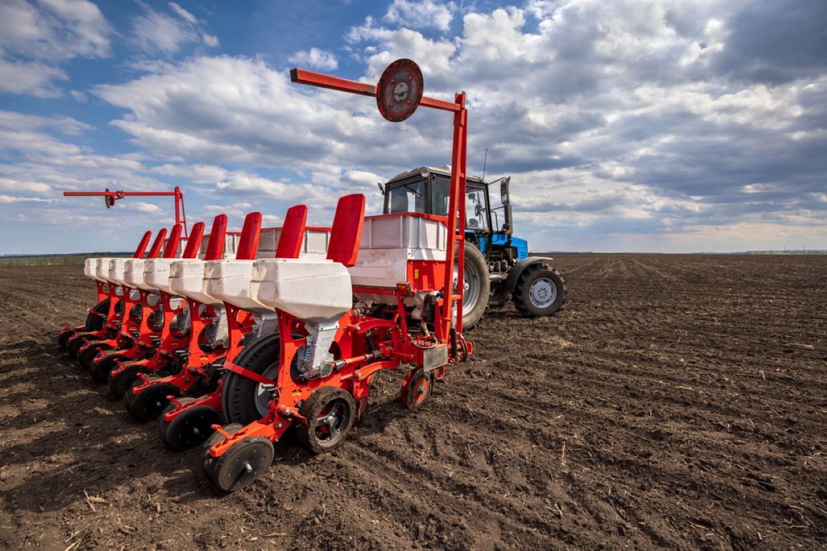 A Tractor is Plowing a Field With a Row of Planters — Barnyard Stockfeed, Pet, Garden and Florist in Childers, QLD